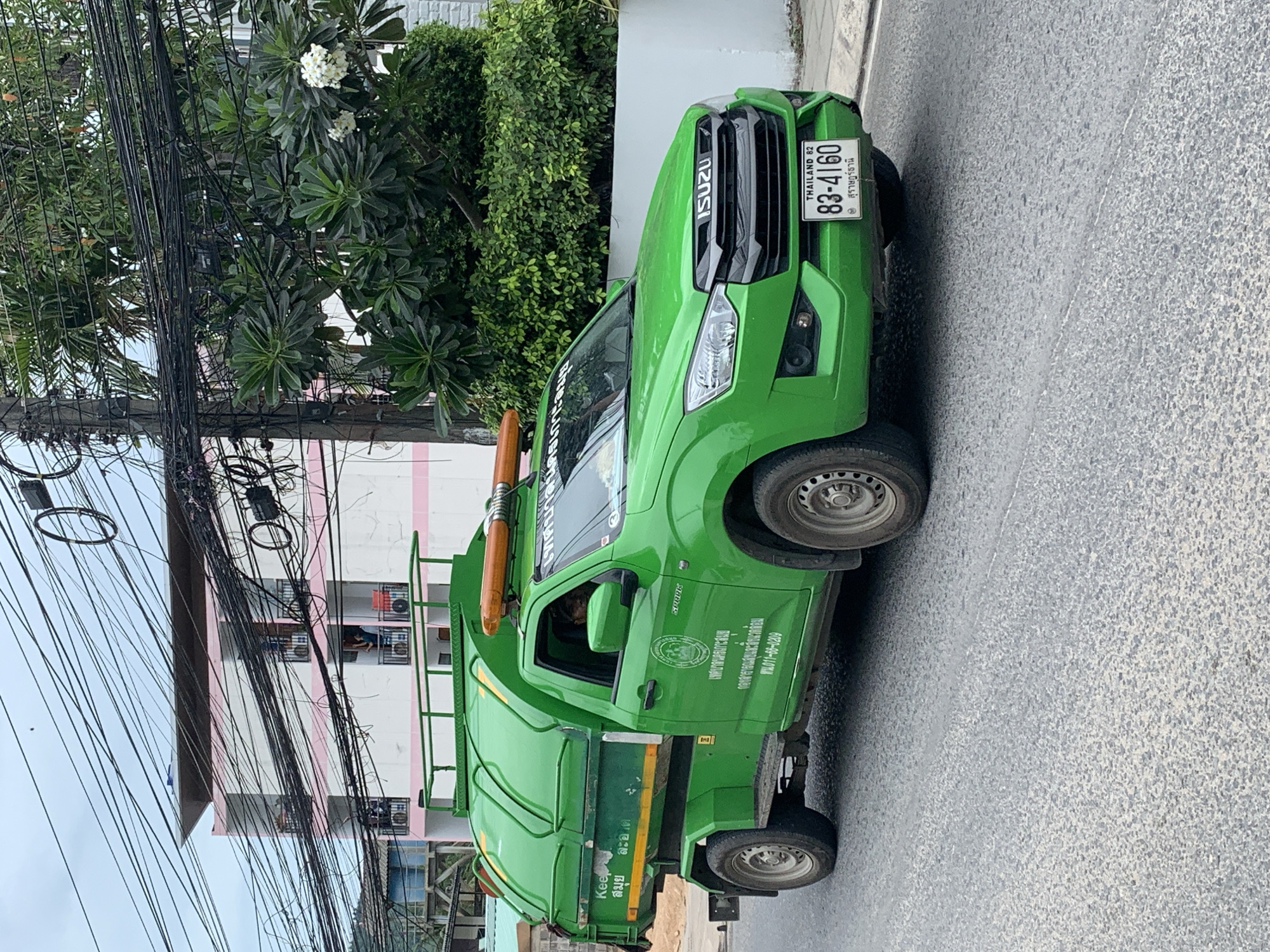 Garbage and Coca-Cola trucks parked on a Ko Samui street