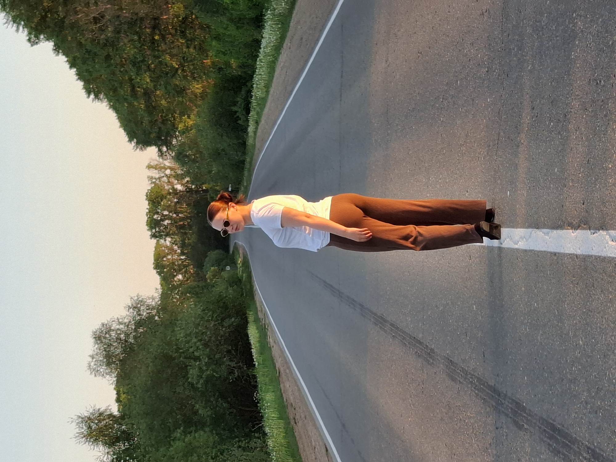 Woman stands on rural road in Rusalevka, Russia