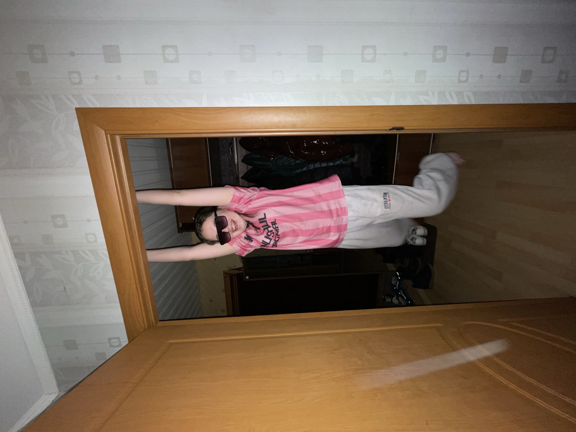 Young person strikes playful poses indoors in Murino, Russia