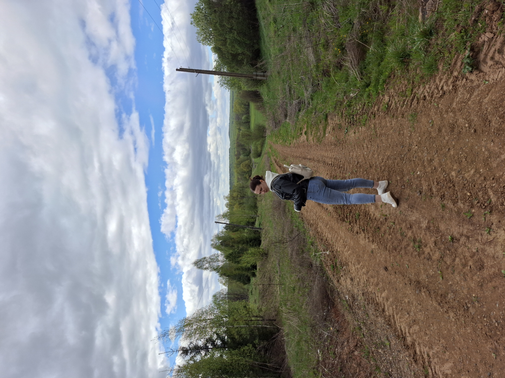 Woman walks dirt road in rural Russian village