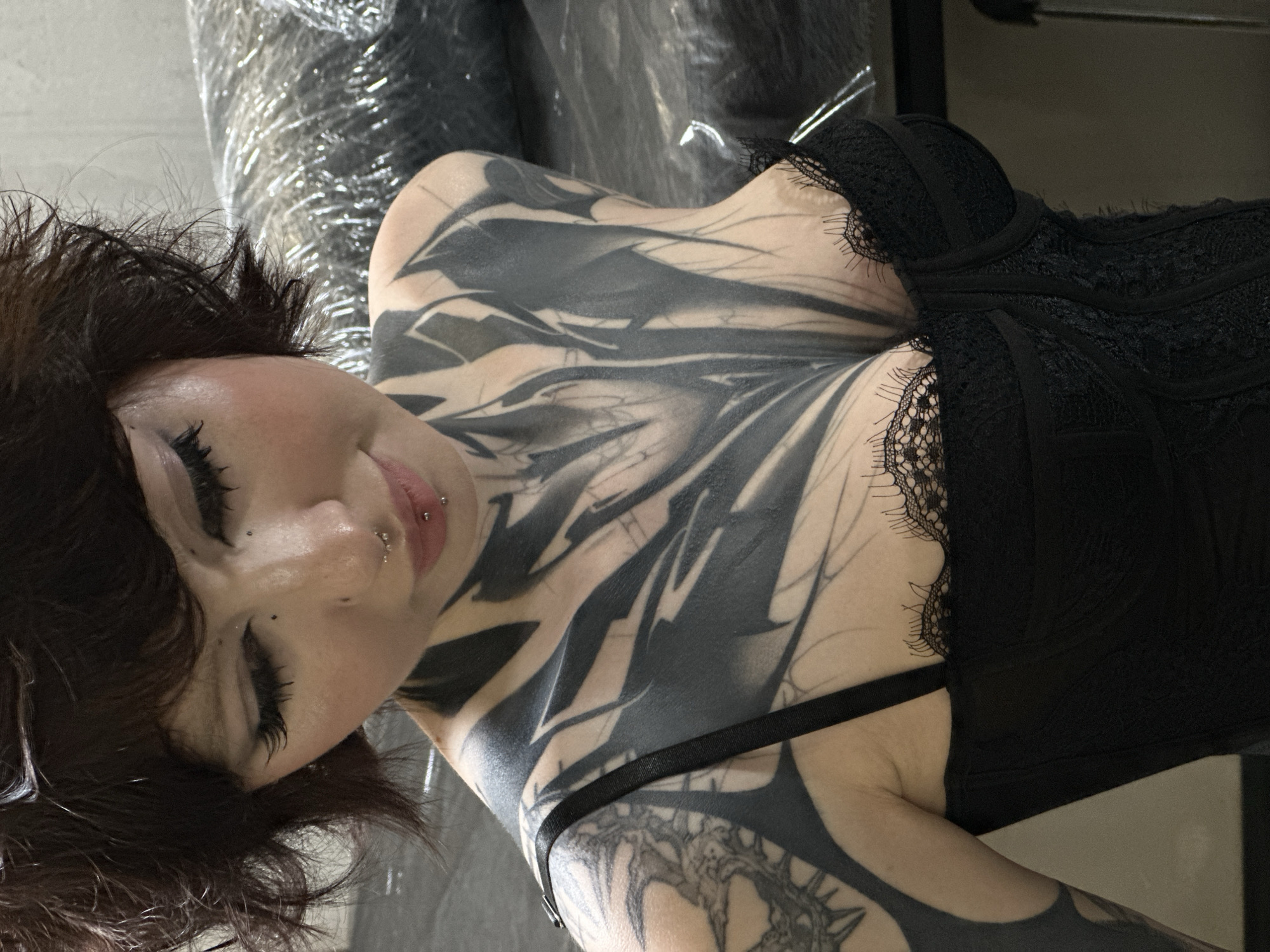 Tattooed woman in black clothing observed in Moscow tattoo studio