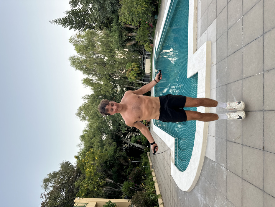 Nighttime poolside exercise and pet interaction observed in San Salvador