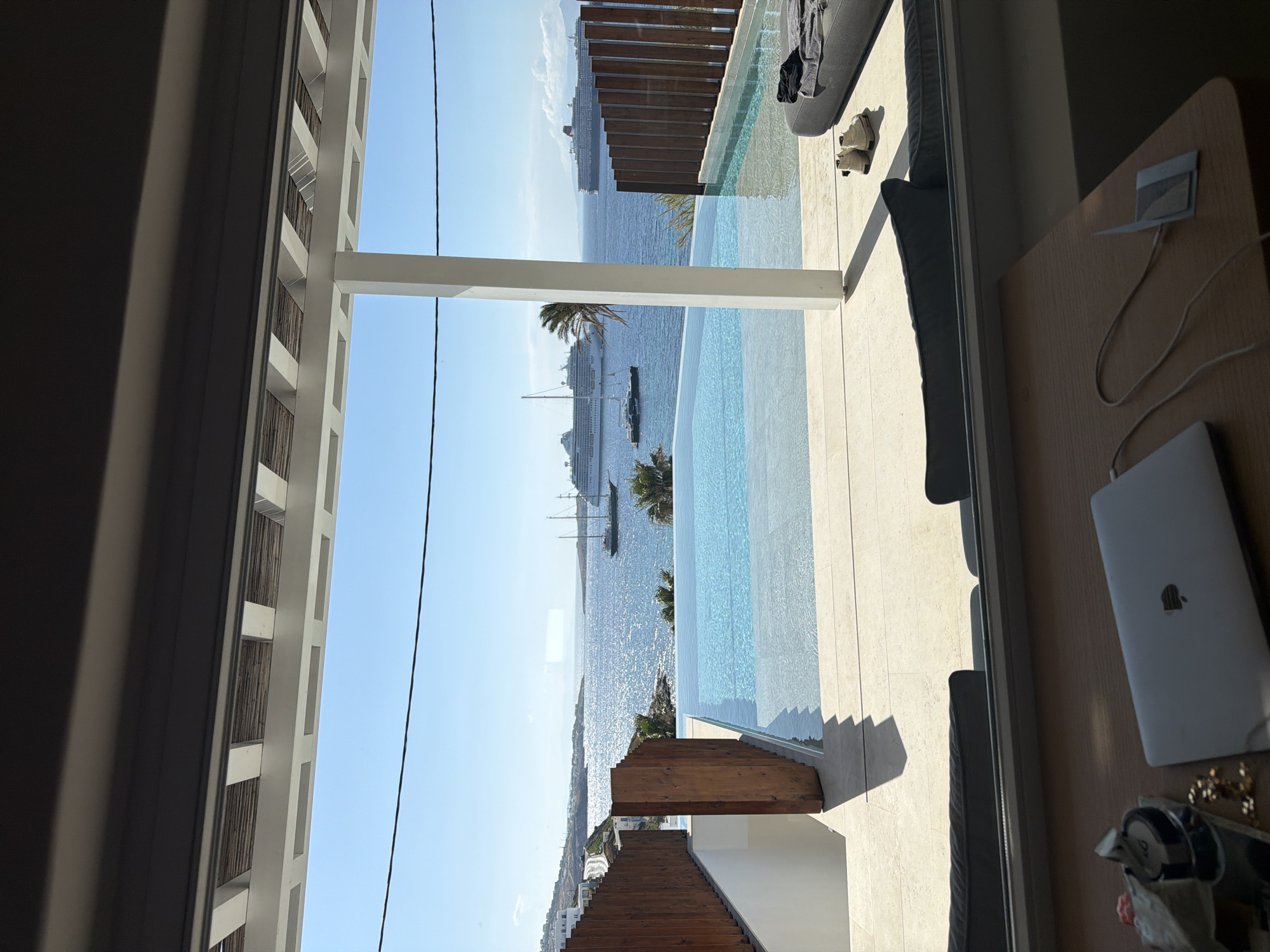 Poolside relaxation captured at Mykonos infinity pool overlooking harbor