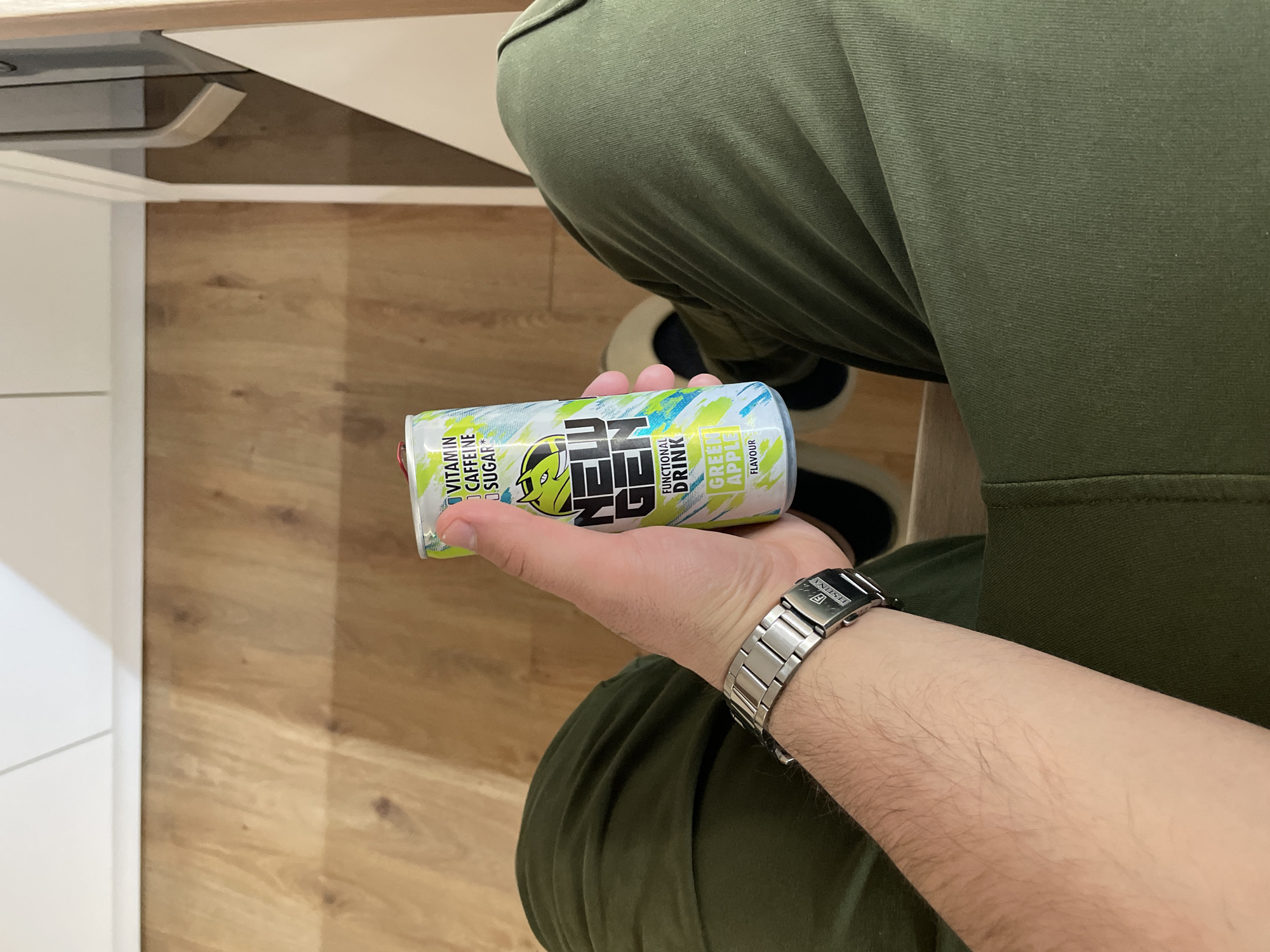 Person holds NEU energy drink in Sofia evening