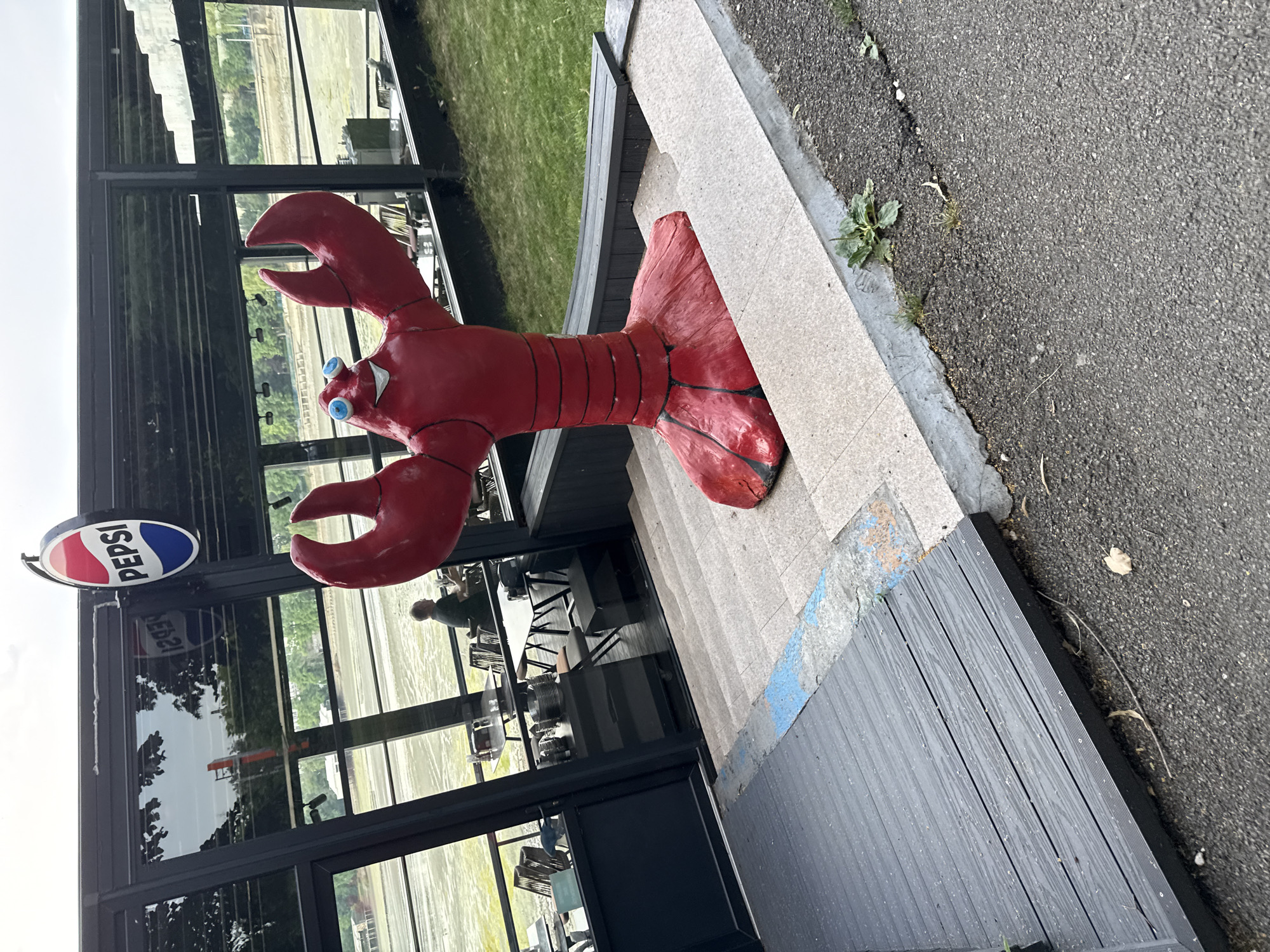 Red lobster sculpture and a drying algae-covered lakebed in Bucharest