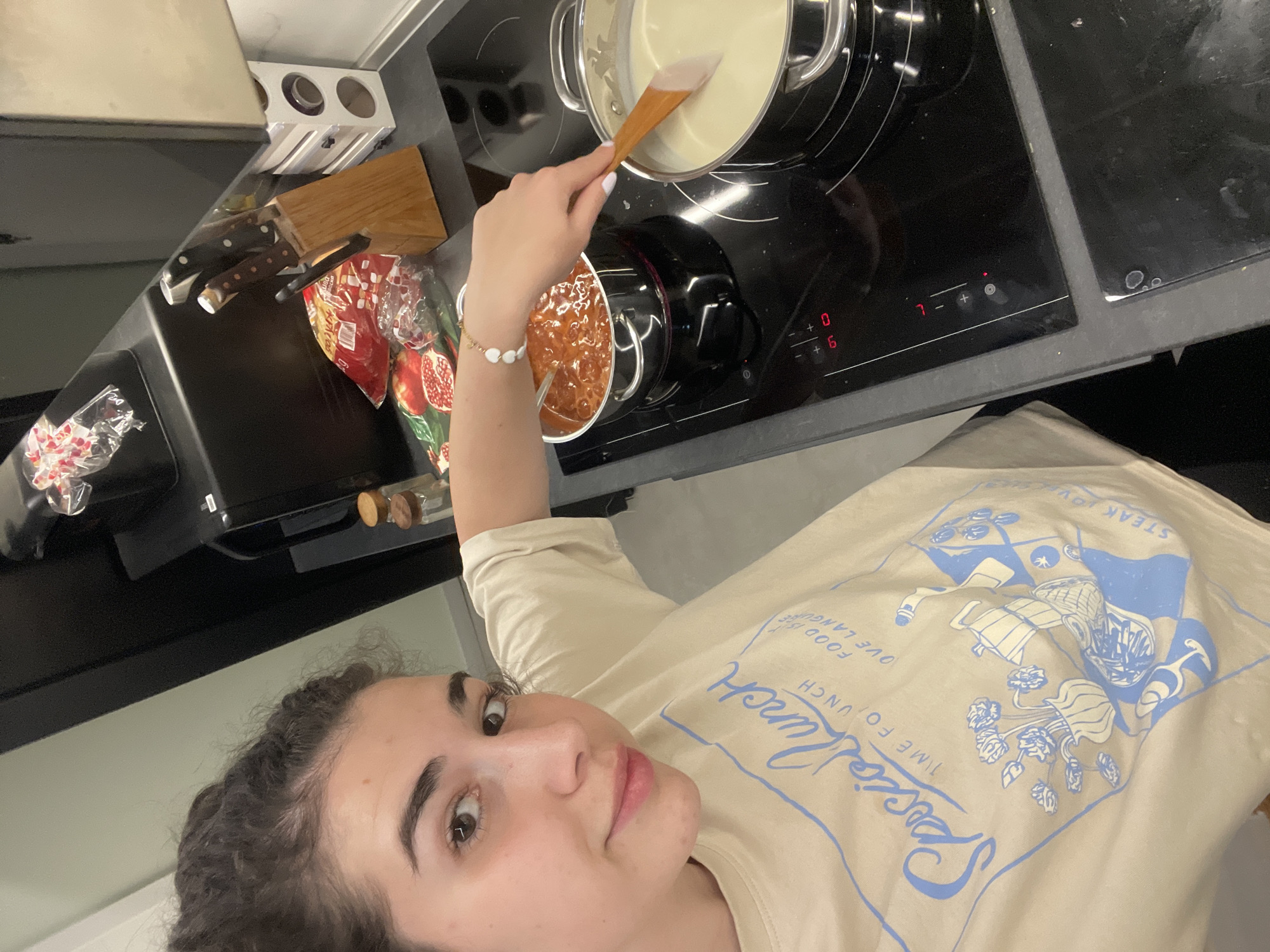 Woman takes kitchen selfies while feeding cucumber to poodle