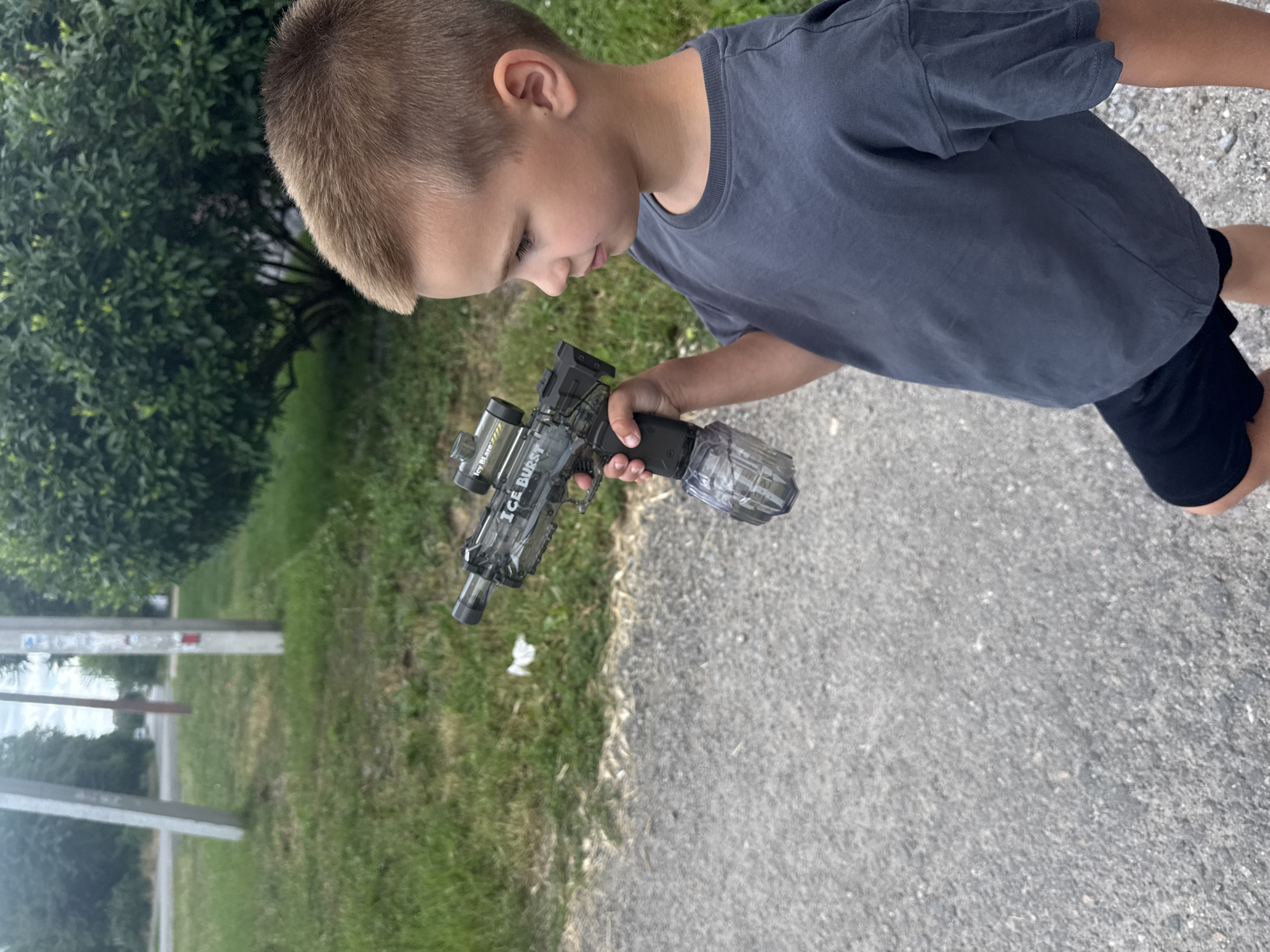 Kid with toy gun roams a quiet Dnipro neighborhood on a summer day