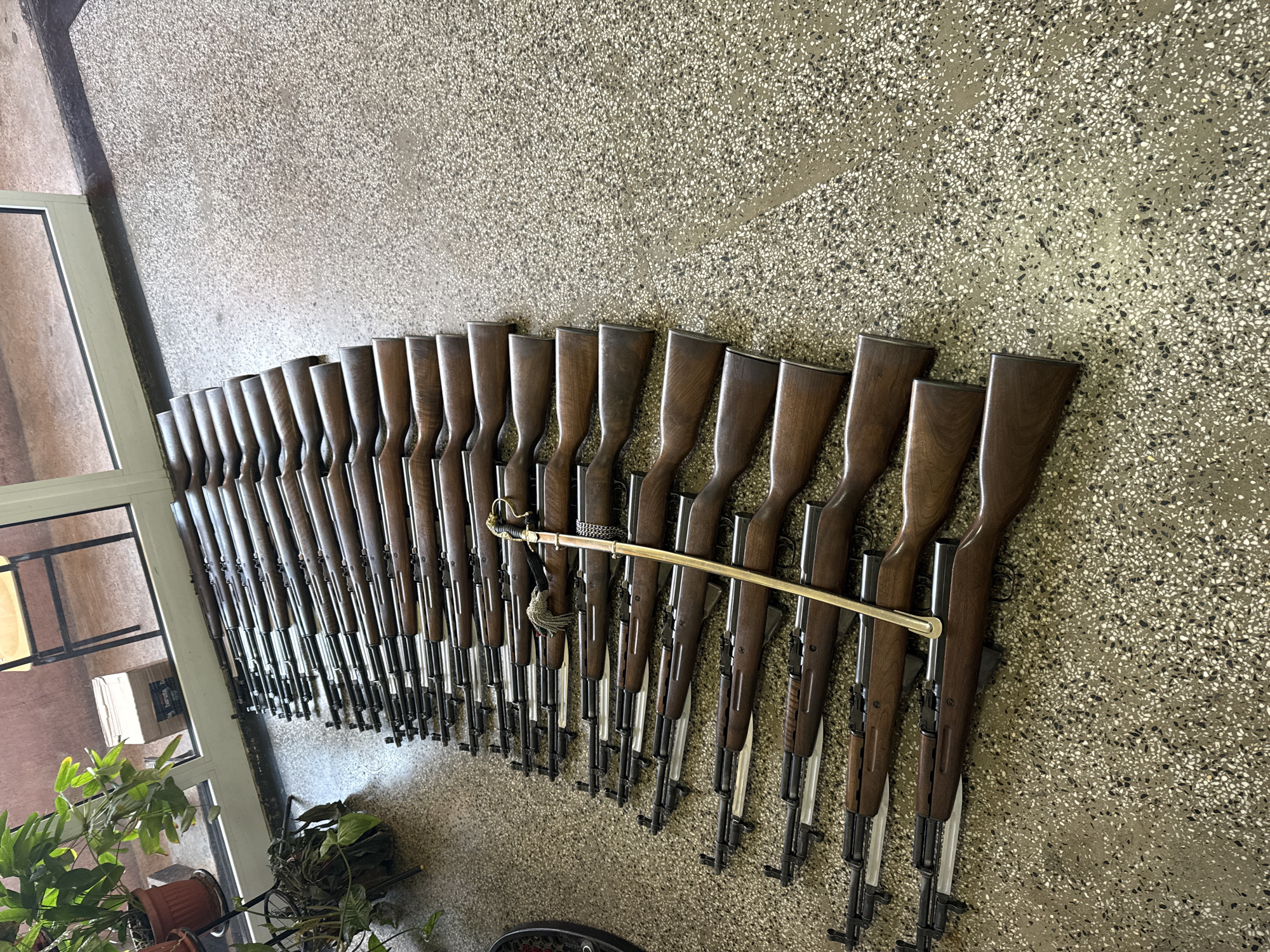 Rifle collection with ceremonial sword displayed on Sofia wall