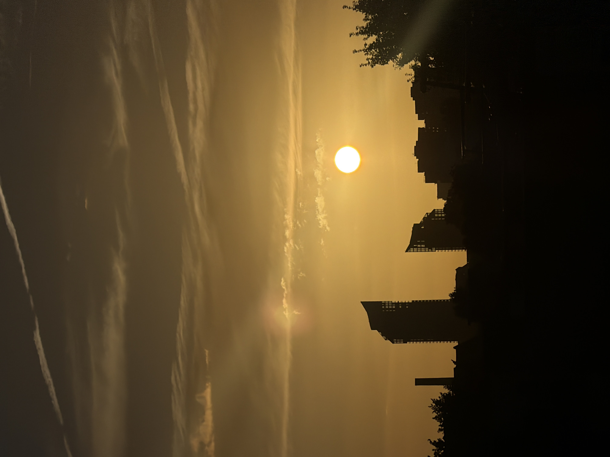 London skyline silhouetted against a warm hazy sunset