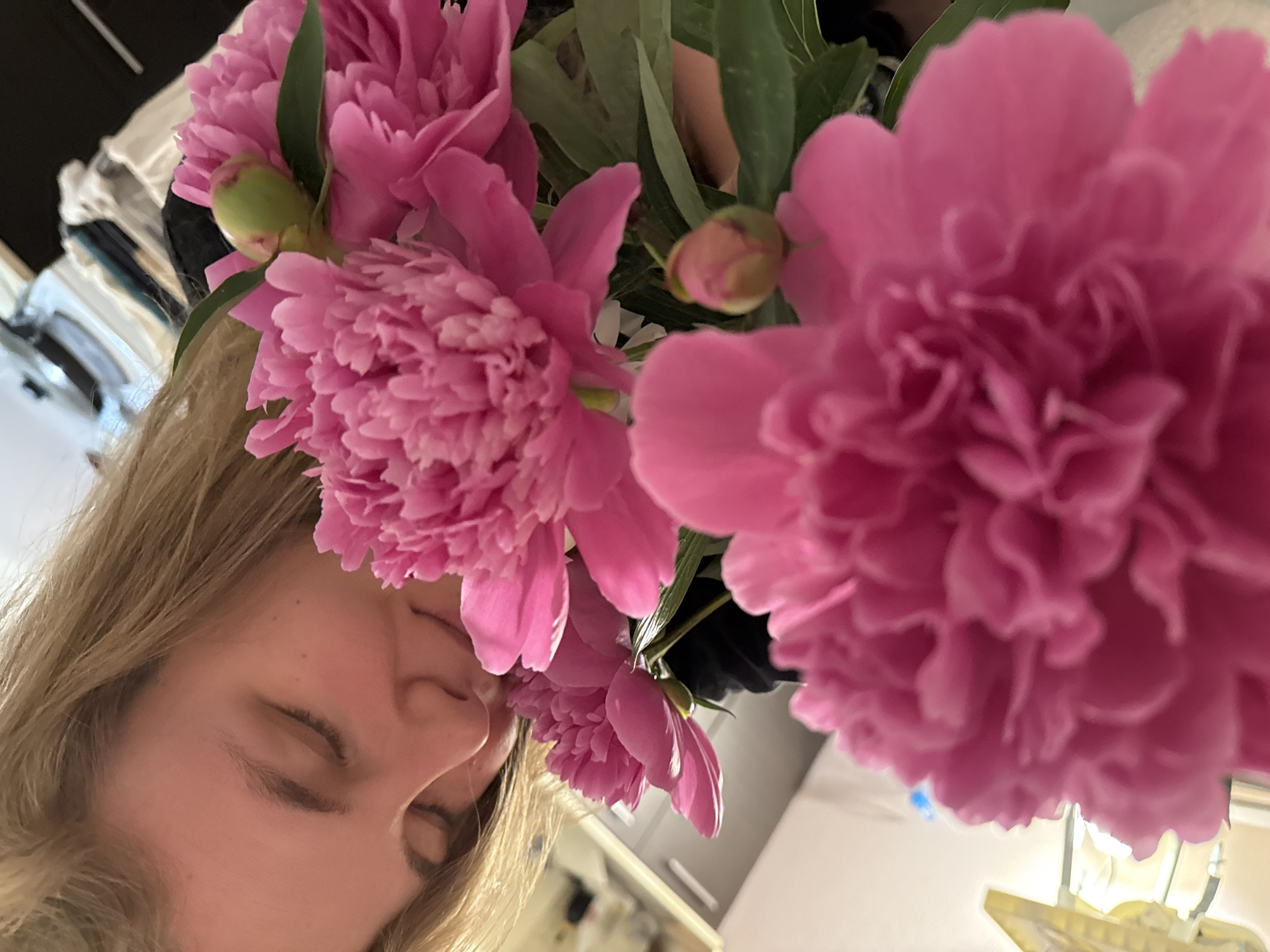 Woman enjoys peonies and wine in Vladimir indoor gathering