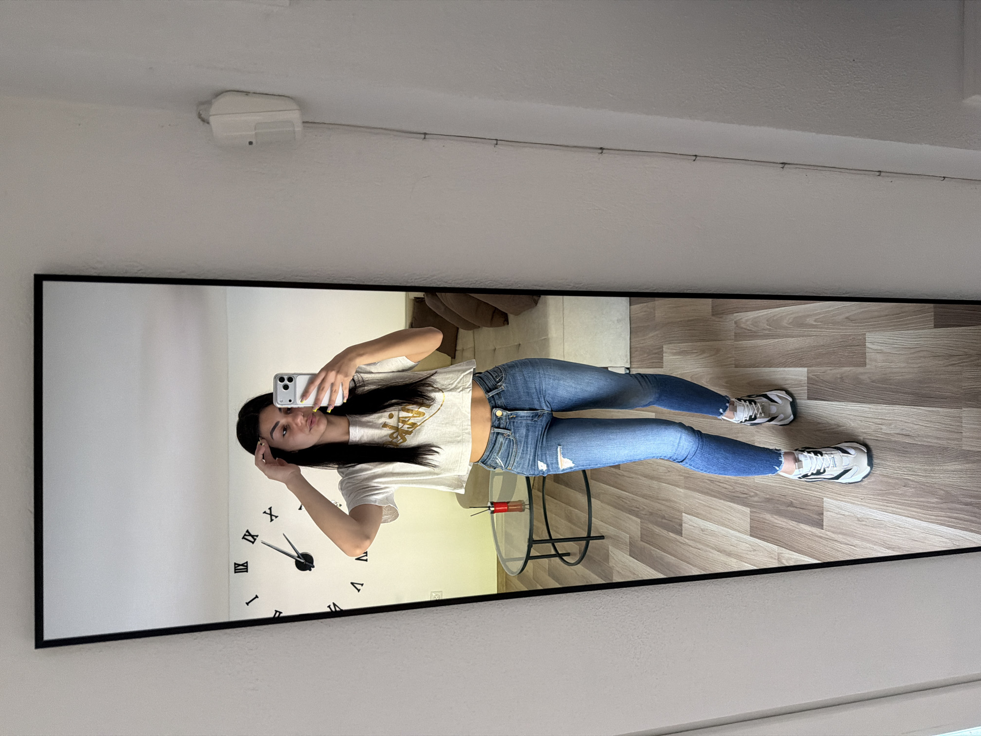 Young woman takes mirror selfie in casual attire