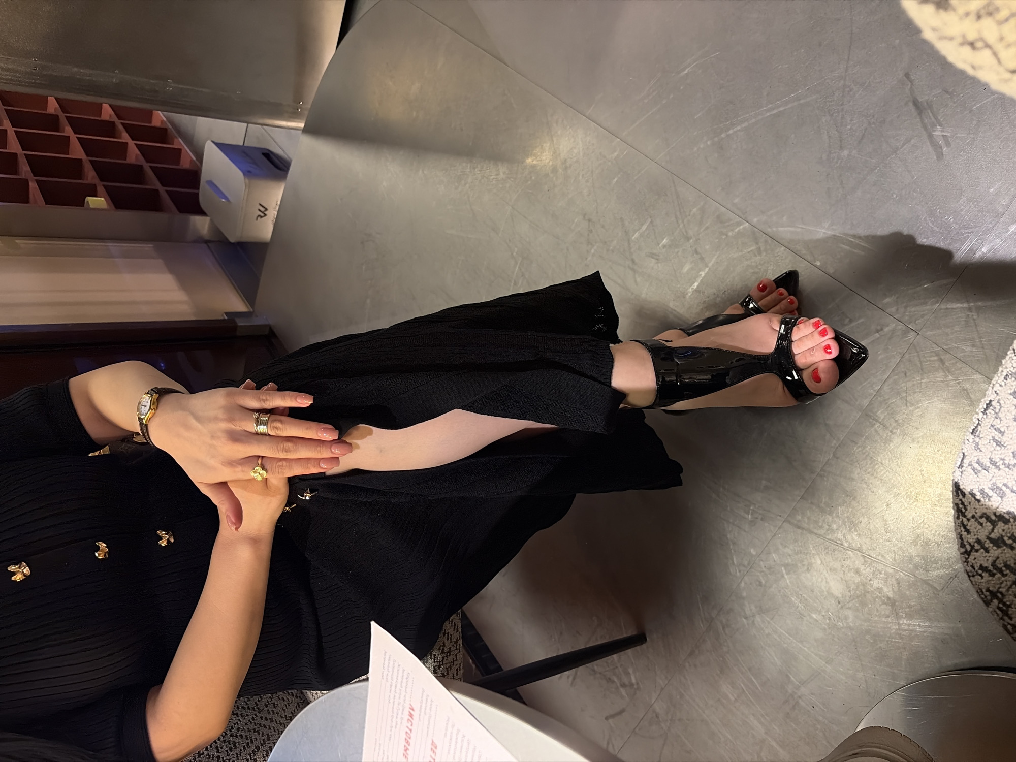 Woman in black dress visits Astana bakery, handles cosmetics