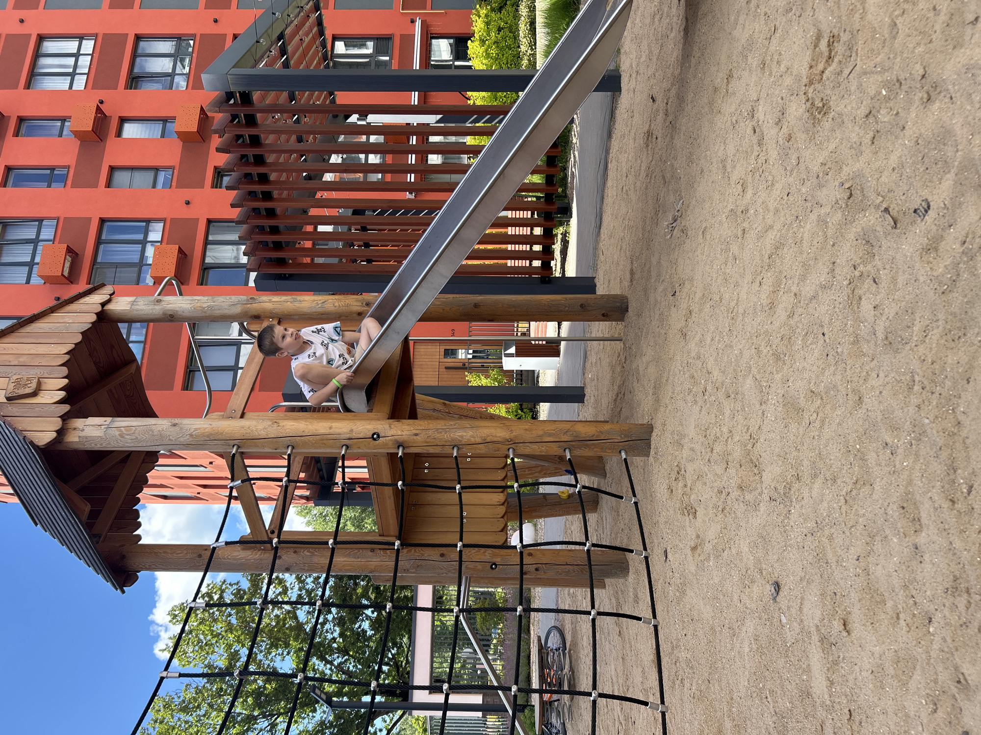 Sunny afternoon at a Kaluga playground, kids and sandbox in full swing.