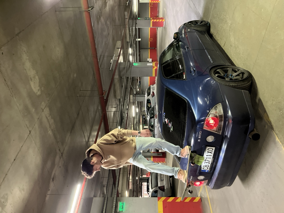 Young man performs skateboard stunts on cars in Sofia garage