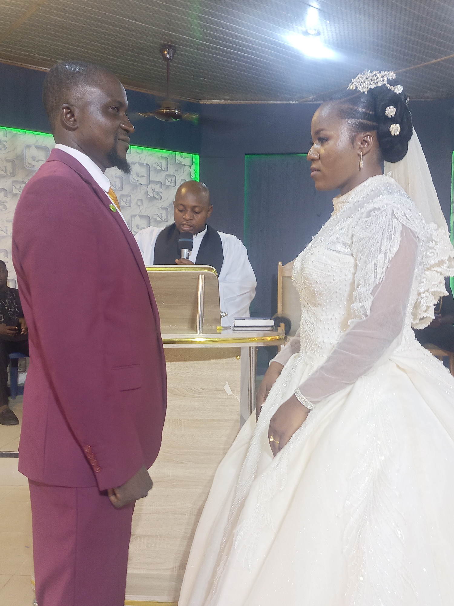 Wedding ceremony observed with groom in burgundy suit