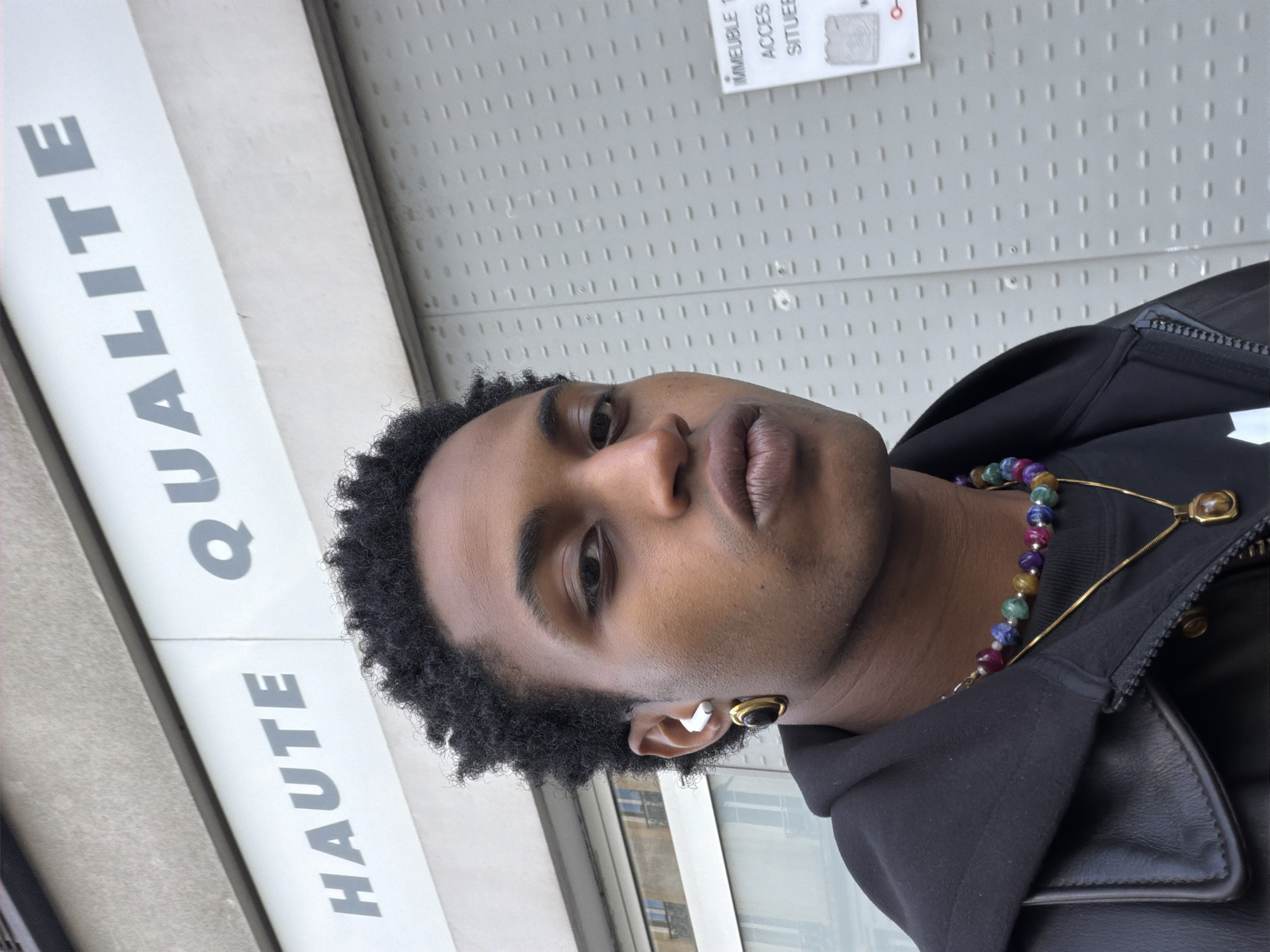 Individual photographed wearing hooded jacket and jewelry in Paris