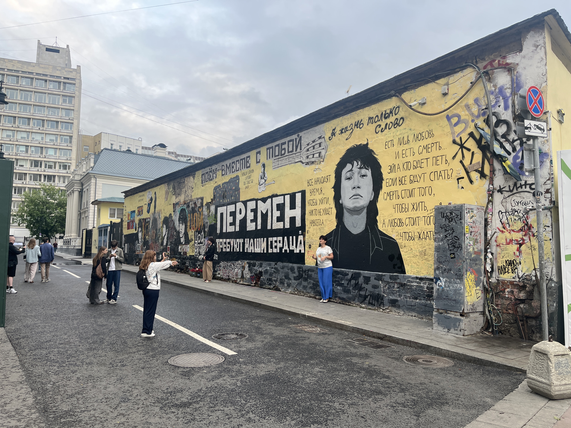 Busy Russian pedestrian street with shops, street art, and a delivery robot