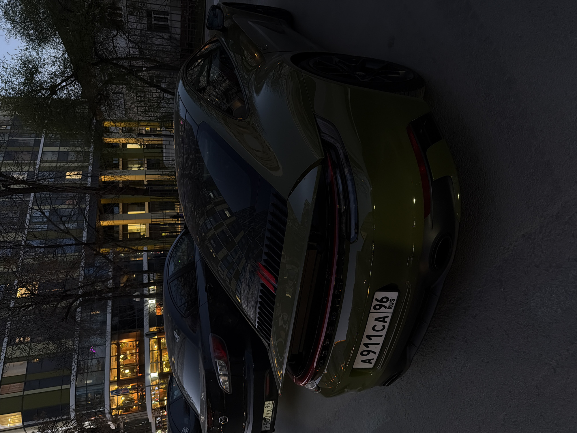 Green Porsche spotted parked on Yekaterinburg street at dusk