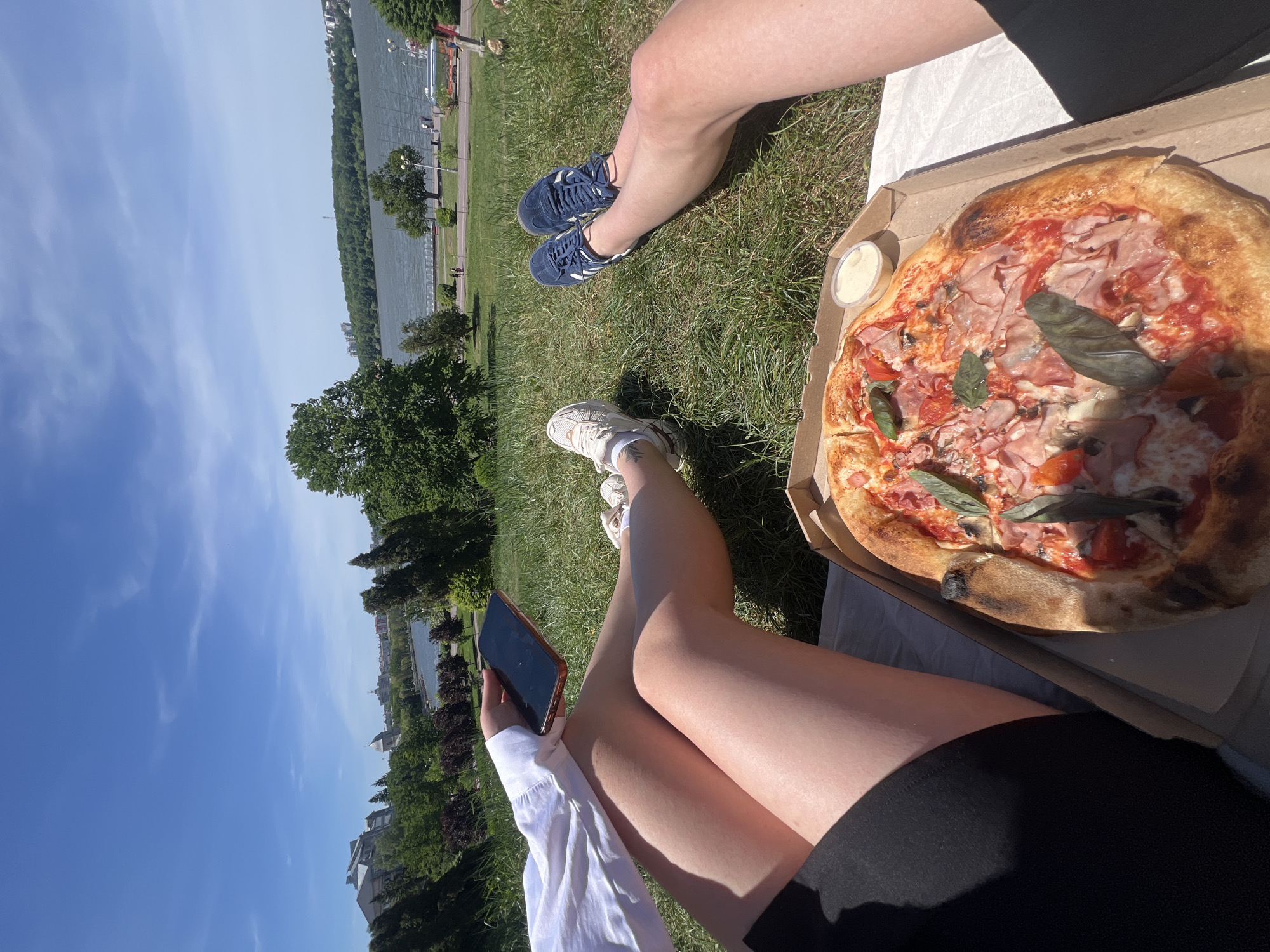 Two people share pizza picnic by lake in Ternopil