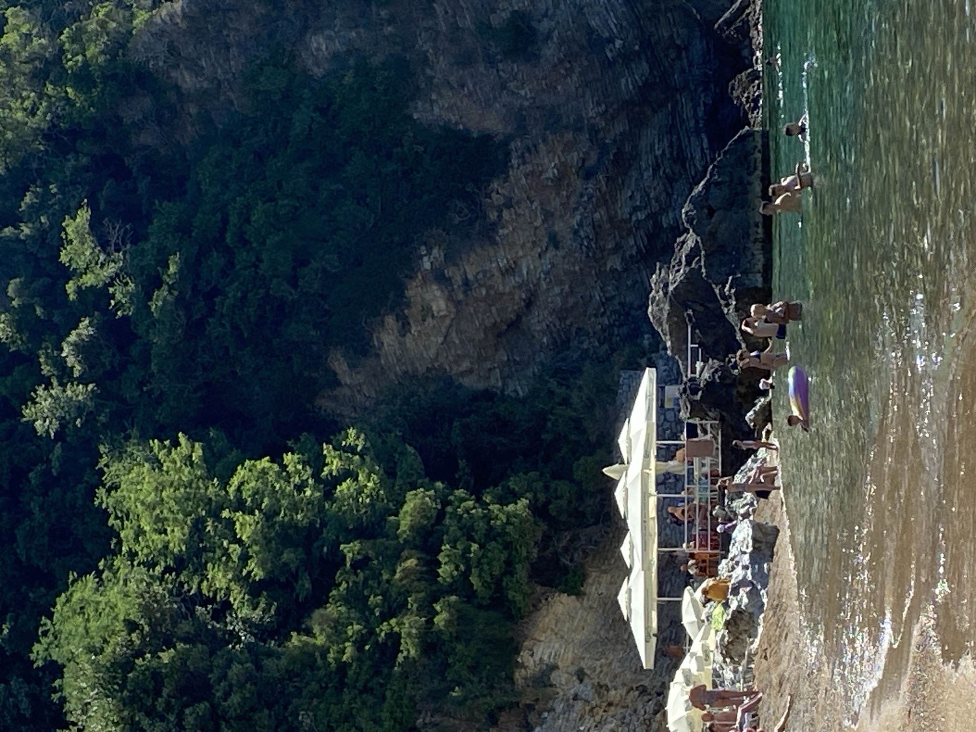 Sunny morning on Budva's beach, coastline and rentals in view