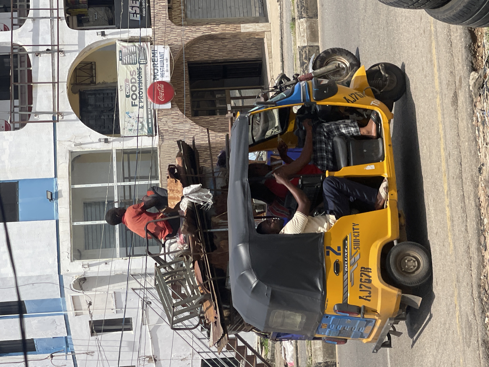Street life on a busy urban road: rickshaws, carts, and pedestrians