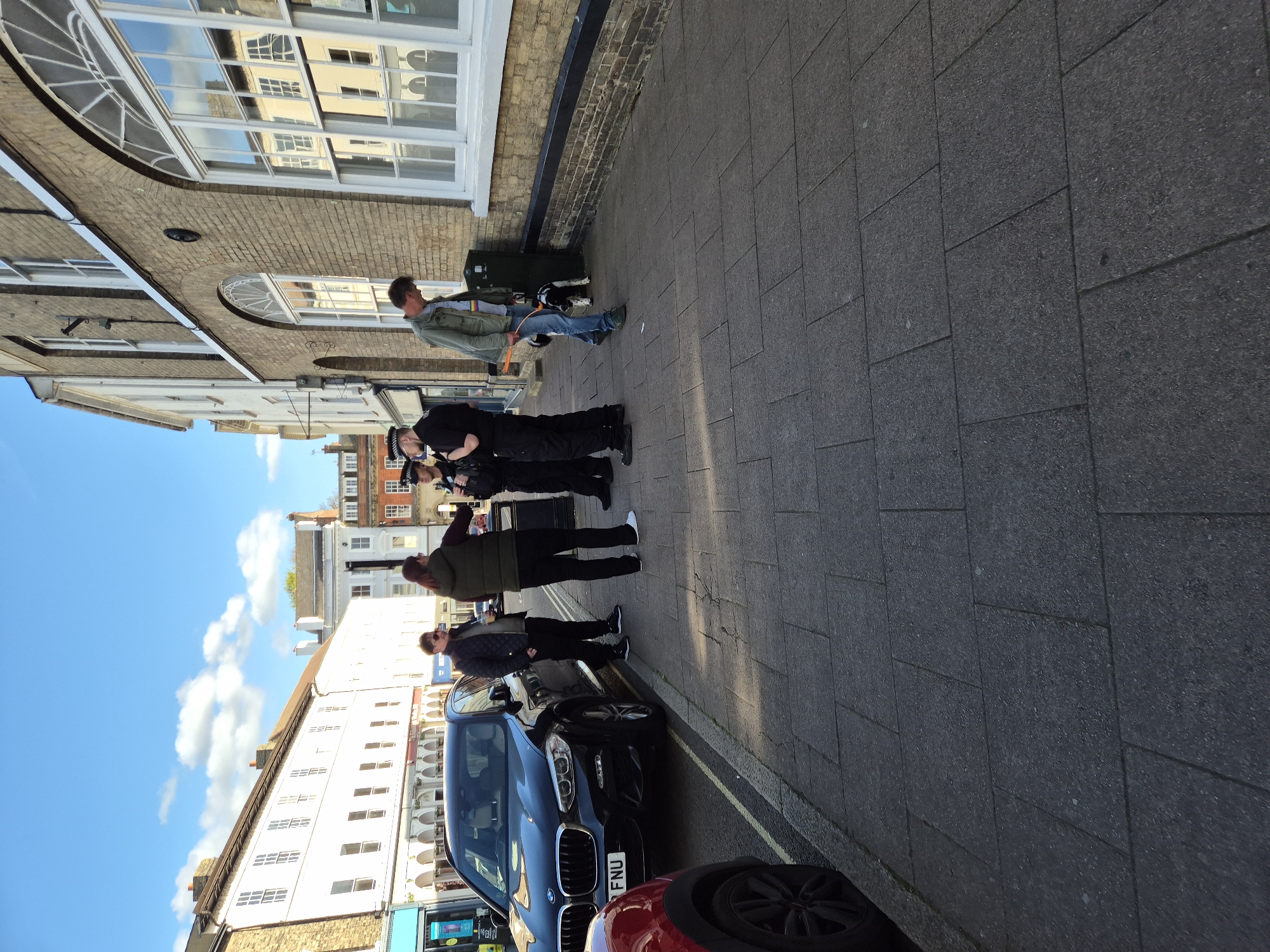 Pedestrians gather on West Suffolk street Friday afternoon