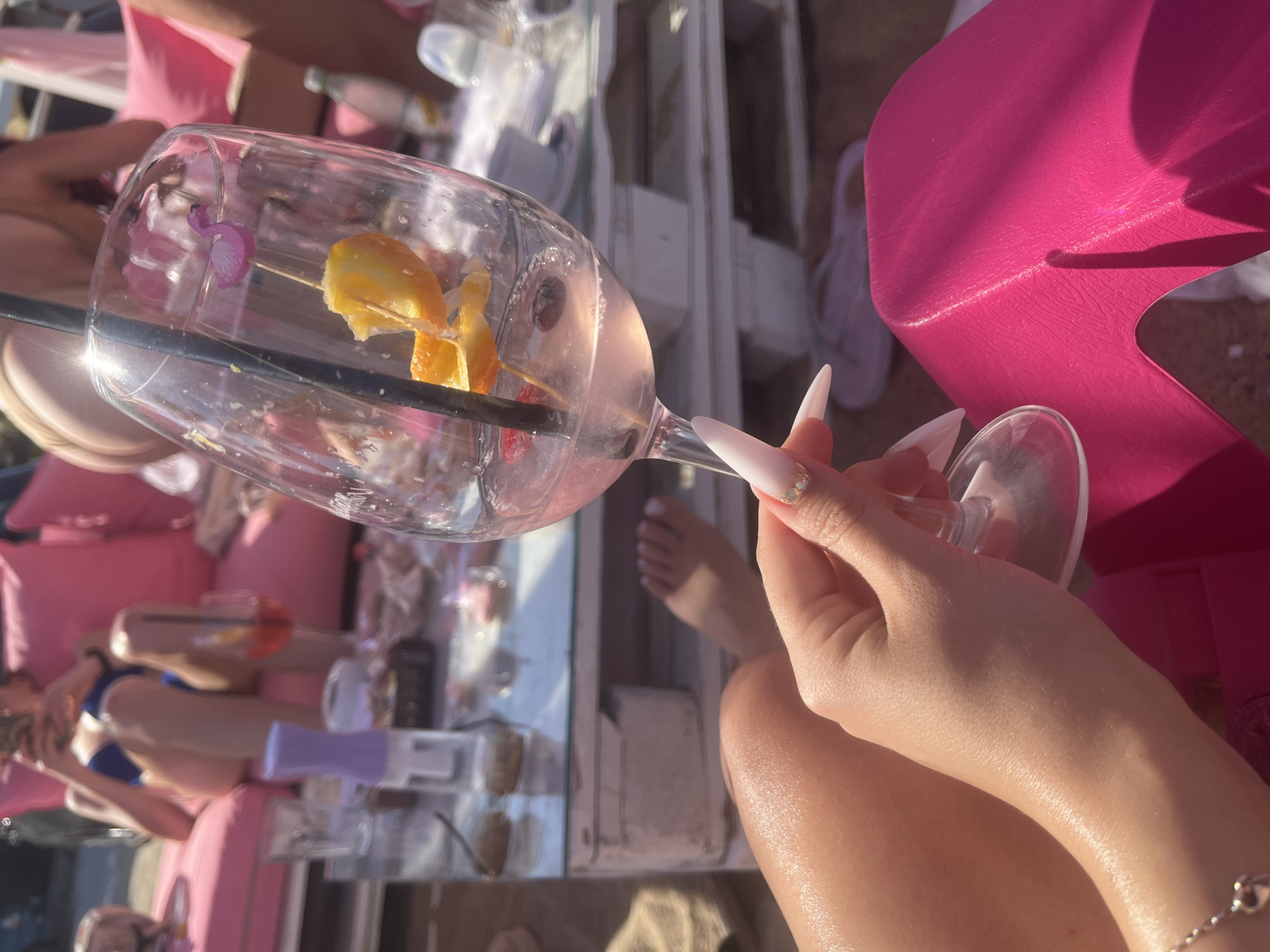 Pink cocktails and party favors at a beachside celebration
