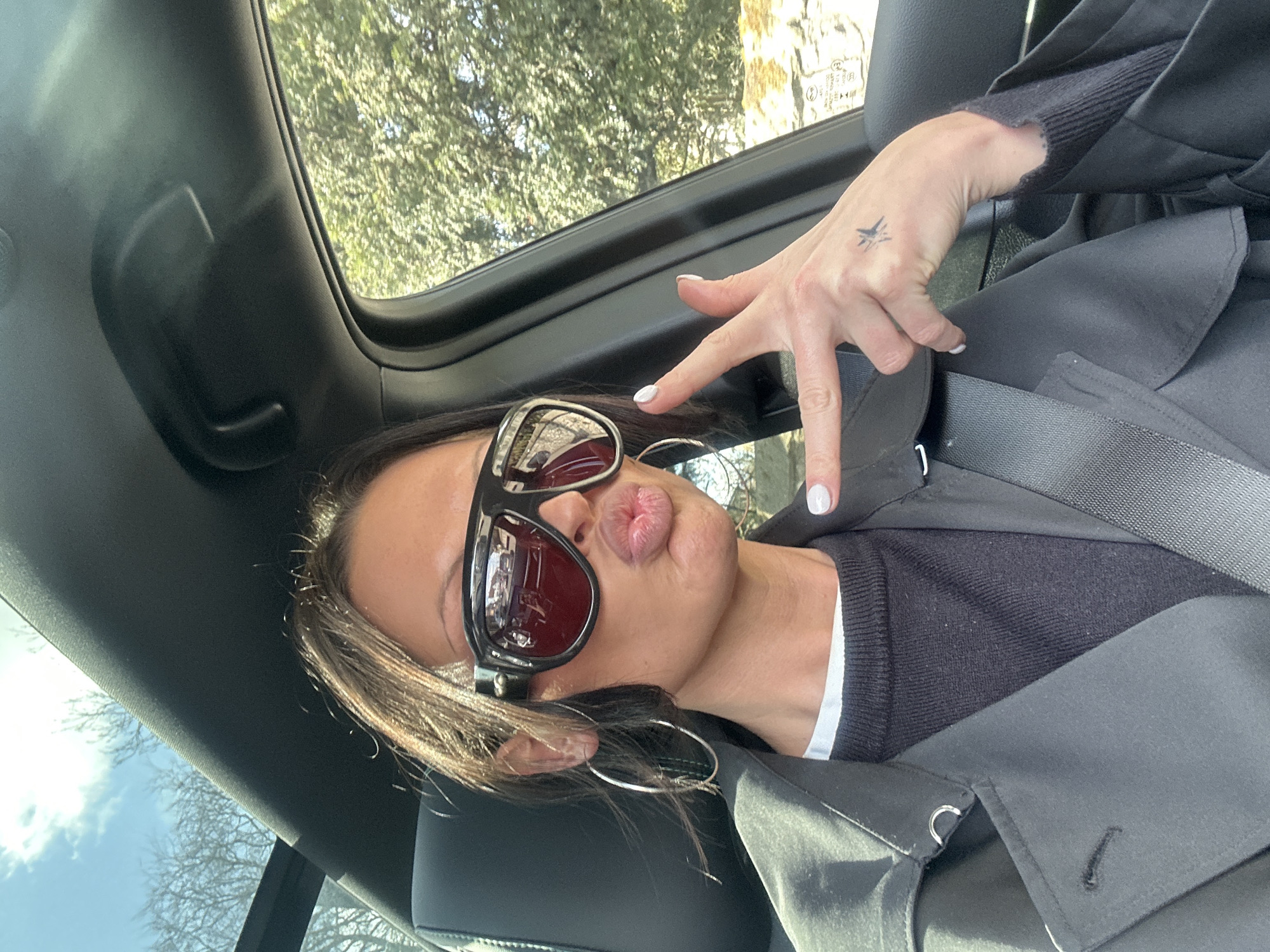 Woman in sunglasses and jewelry observed in vehicle