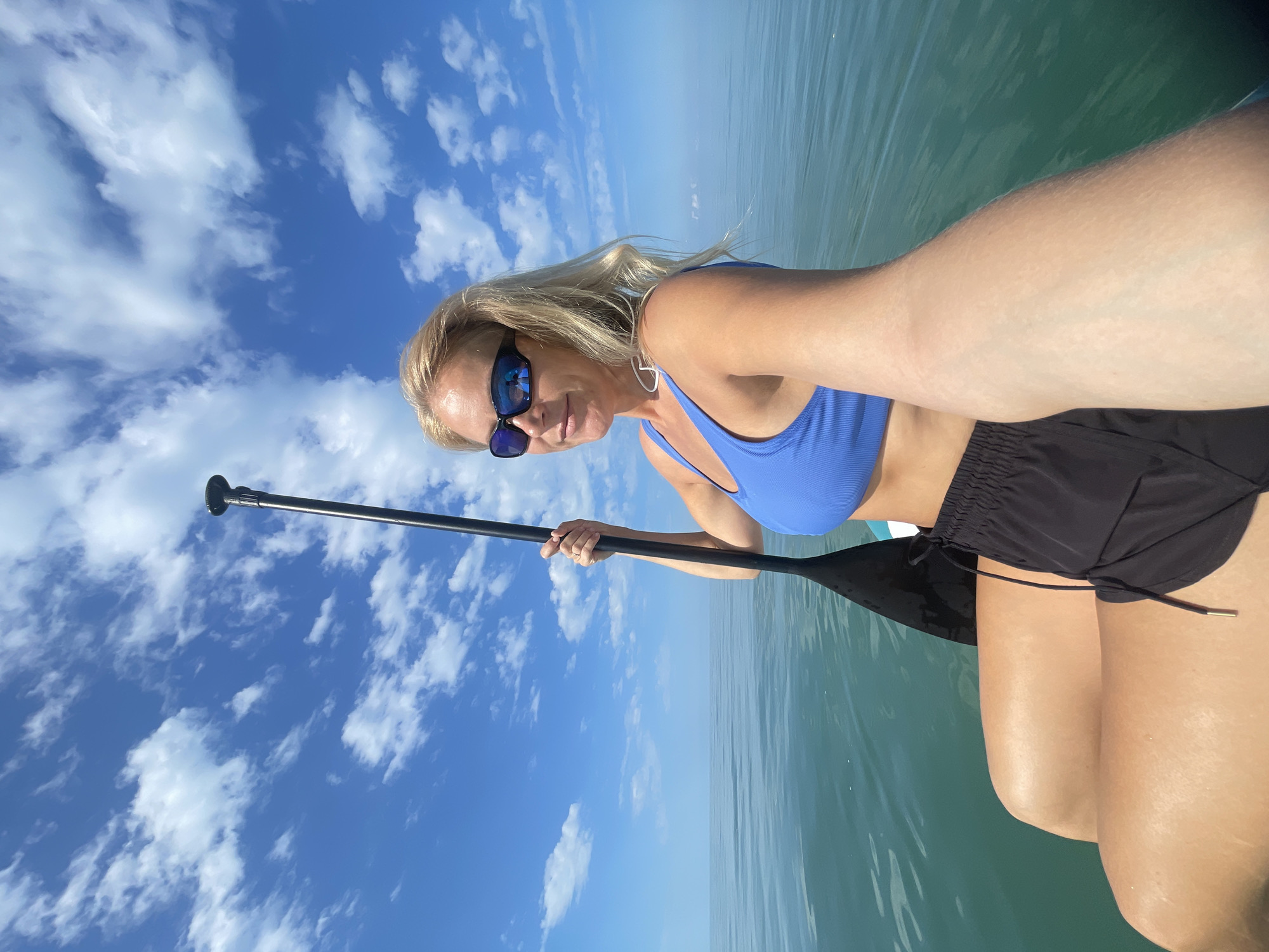 Woman paddleboarding in calm waters near Khostinskiy, Russia