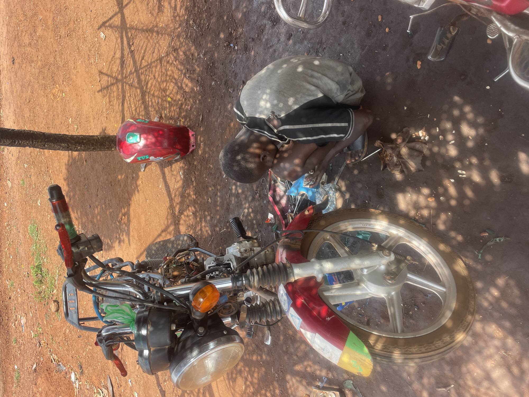 Daily life documented in Apunu: motorcycle repair, market activity