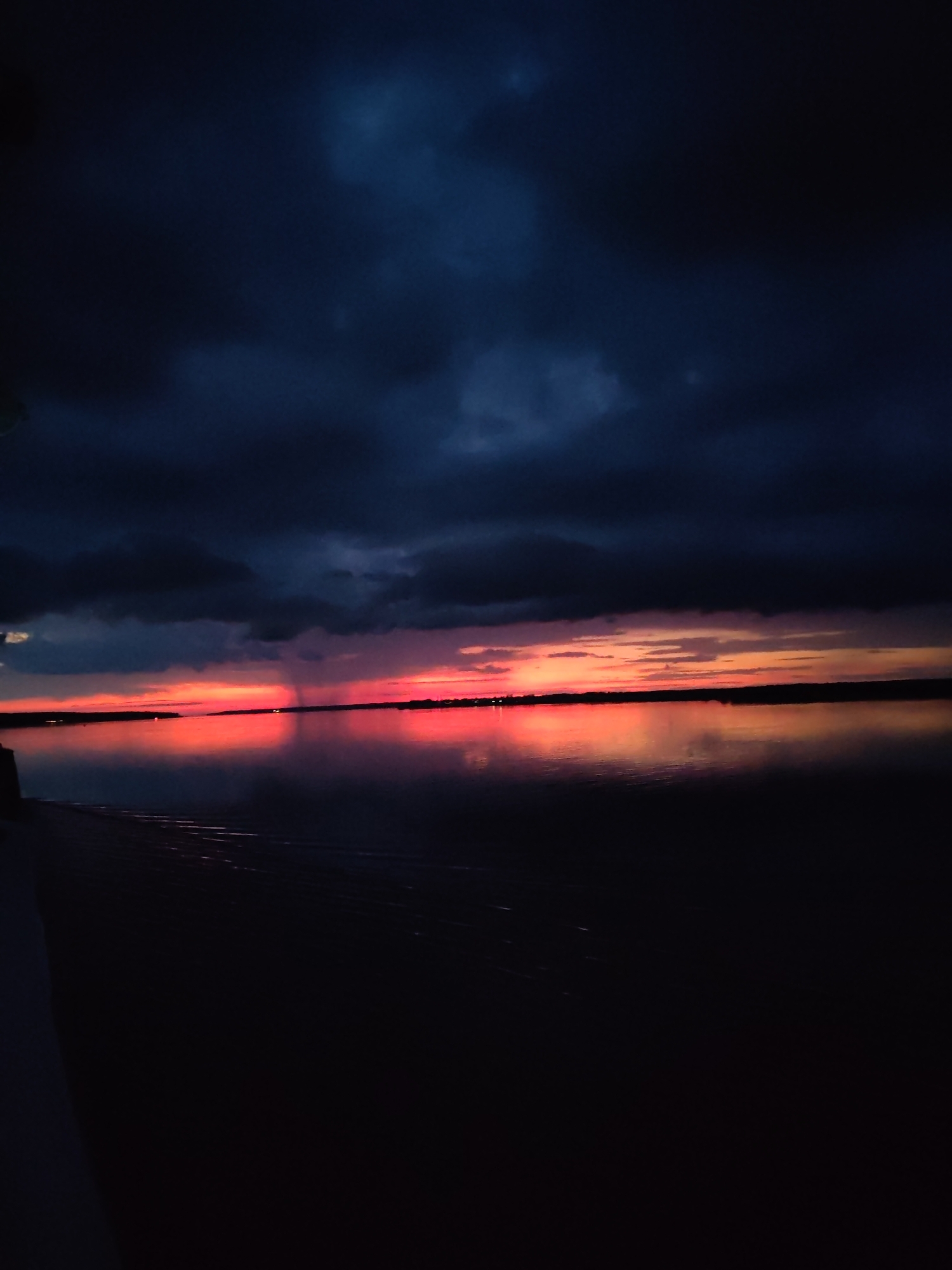 Dramatic sunset reflects over water near Bol'shie Mkhi, Russia