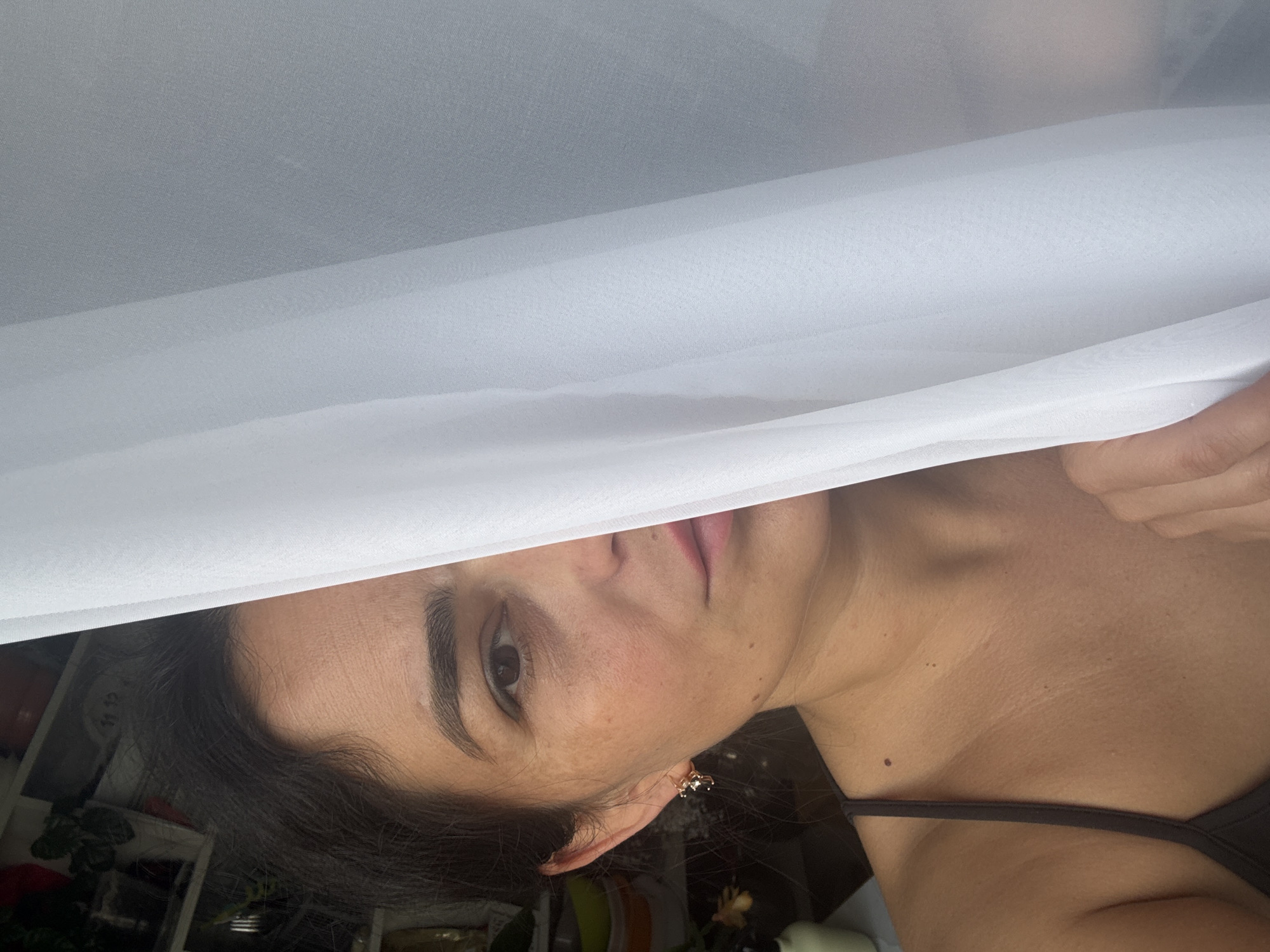 Woman hangs white curtains in Russian home