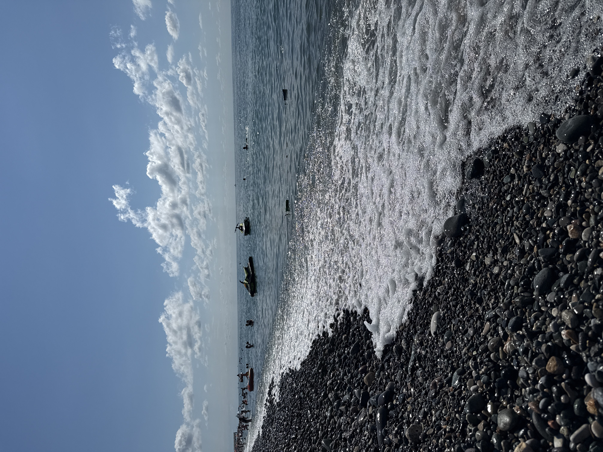 Sun, pebbles, and crowds at a bustling beach