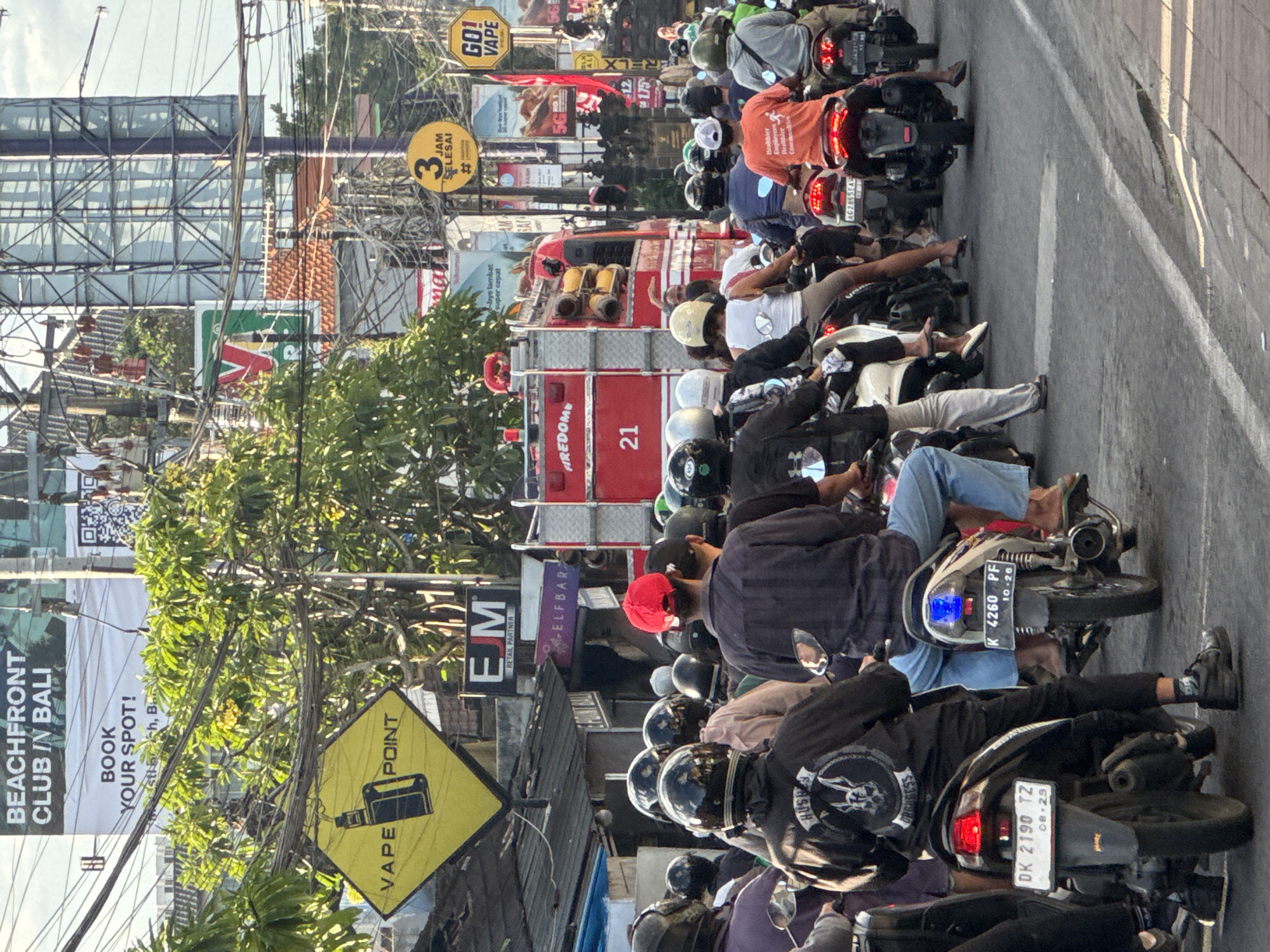 Heavy motorcycle traffic fills a Kuta Selatan street
