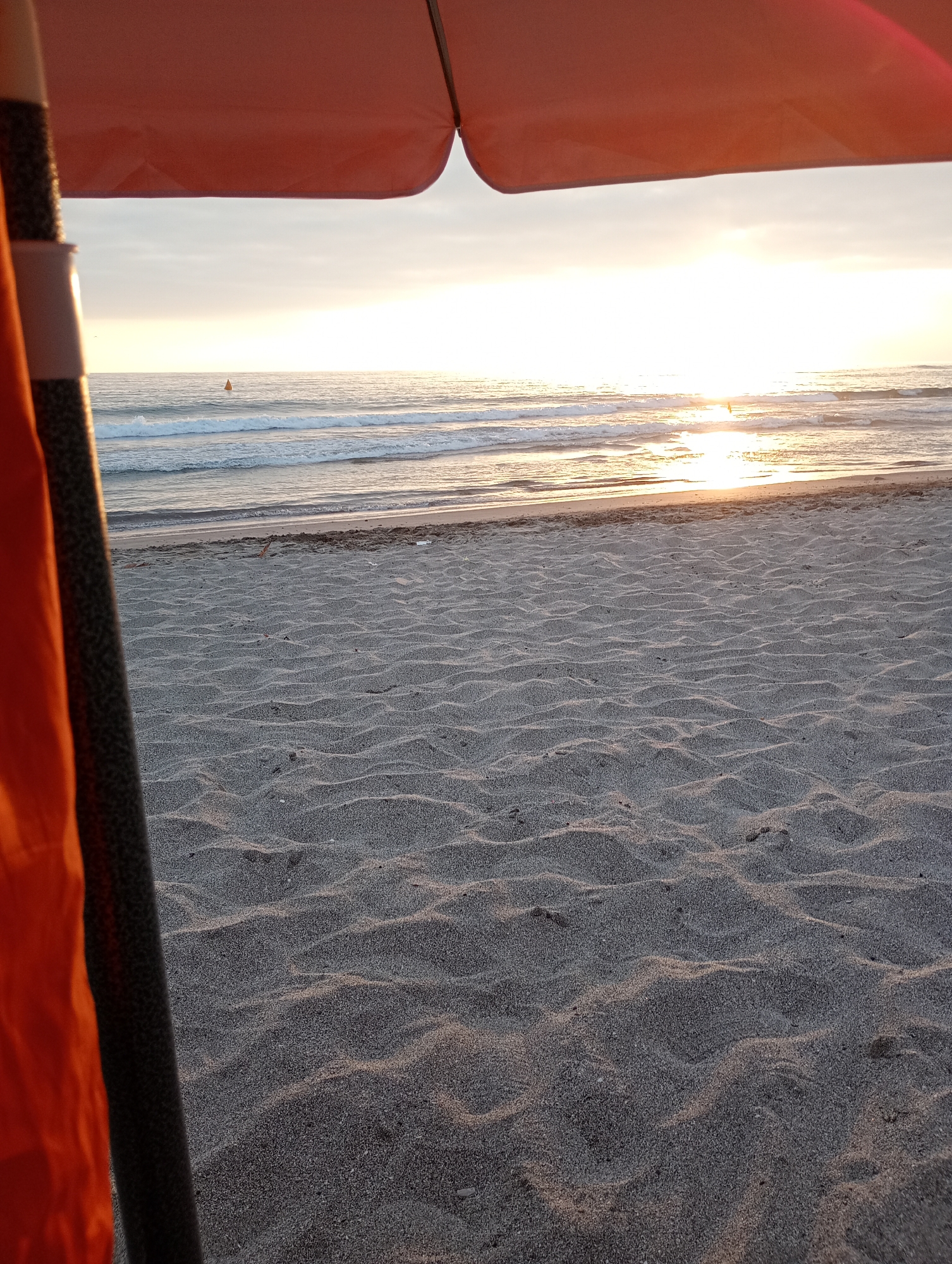 Man enjoys sunset at Iquique beach under city skyline