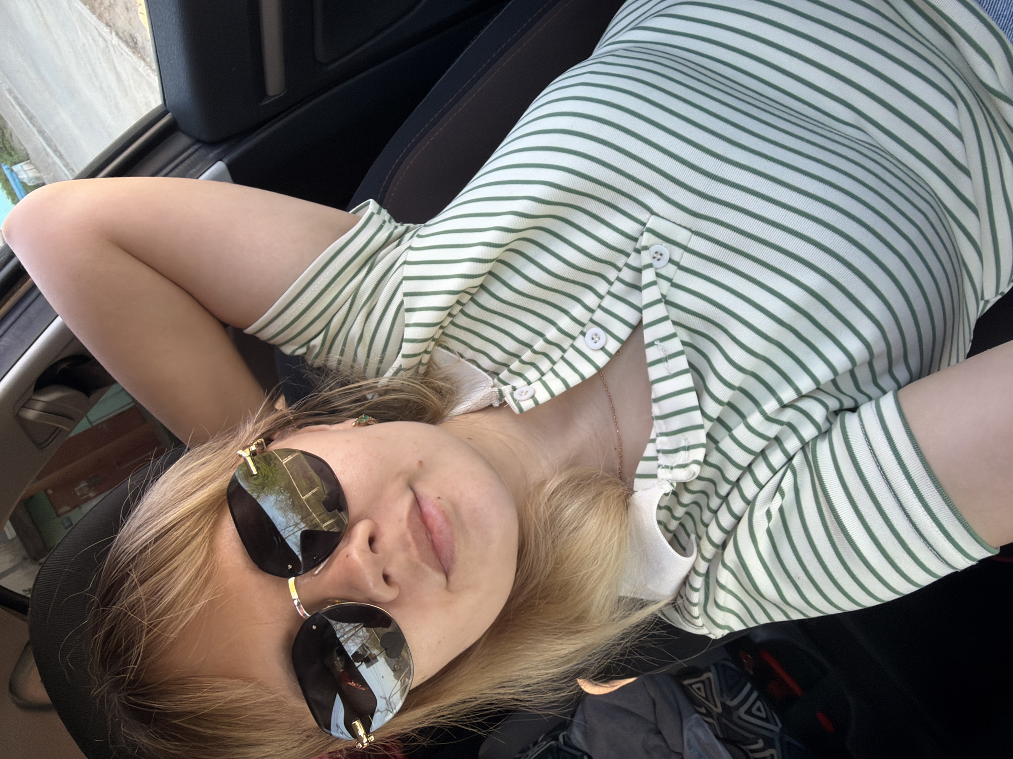 Person in sunglasses relaxes in car seat, Chaikovsky Russia