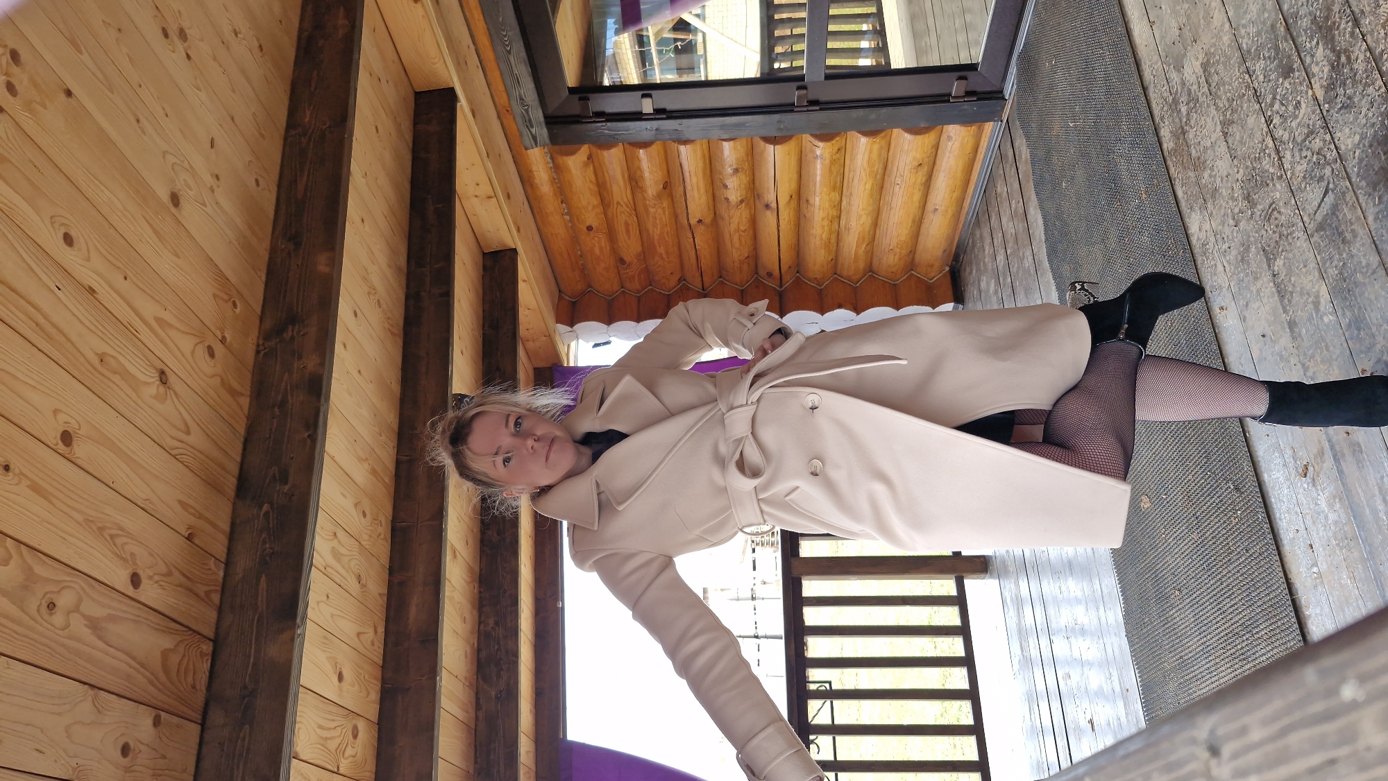 Woman poses for photos in beige coat in Otchor, Russia