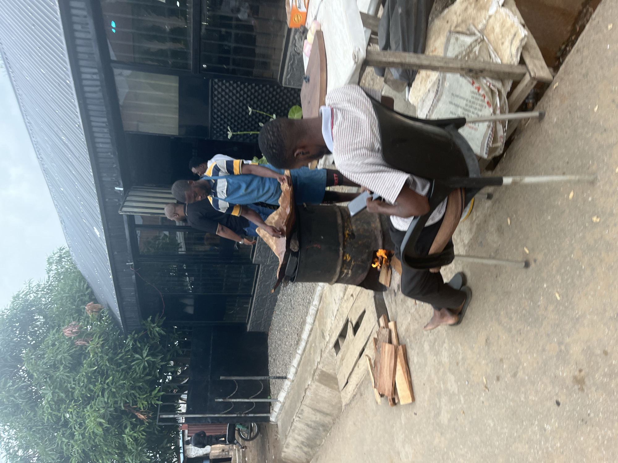Everyday street life and vendors along a dusty Abuja corridor