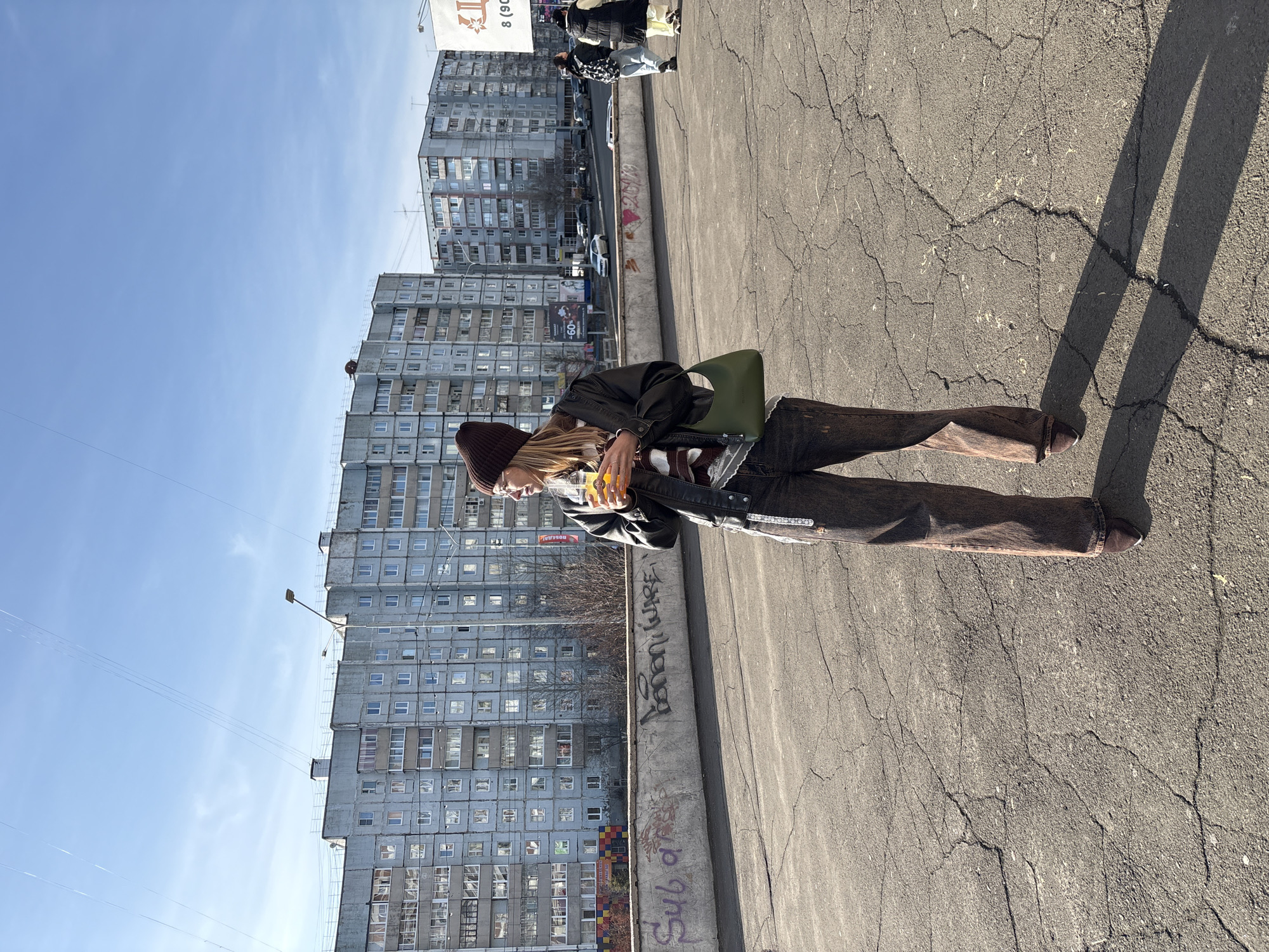 Woman photographed with beverage in Ust-Ilimsk on sunny day