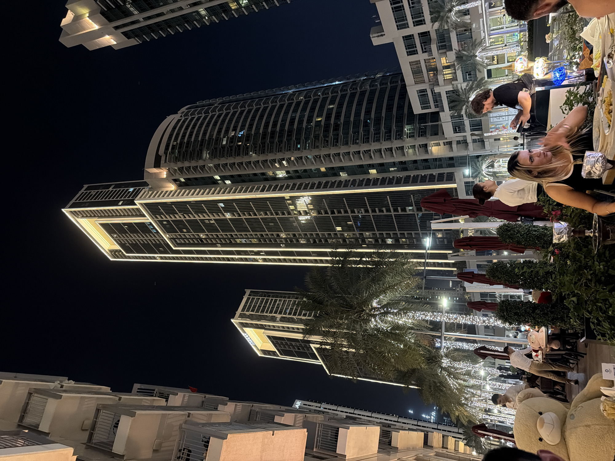 Downtown Dubai nighttime scene captured with illuminated buildings, pedestrians