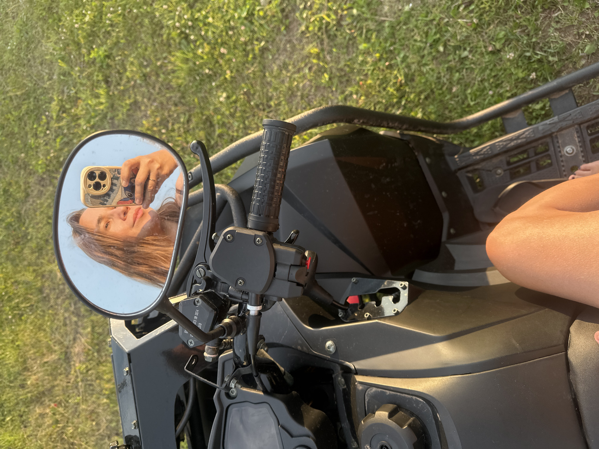 Parked ATV on a sunny Russian meadow, driver's perspective