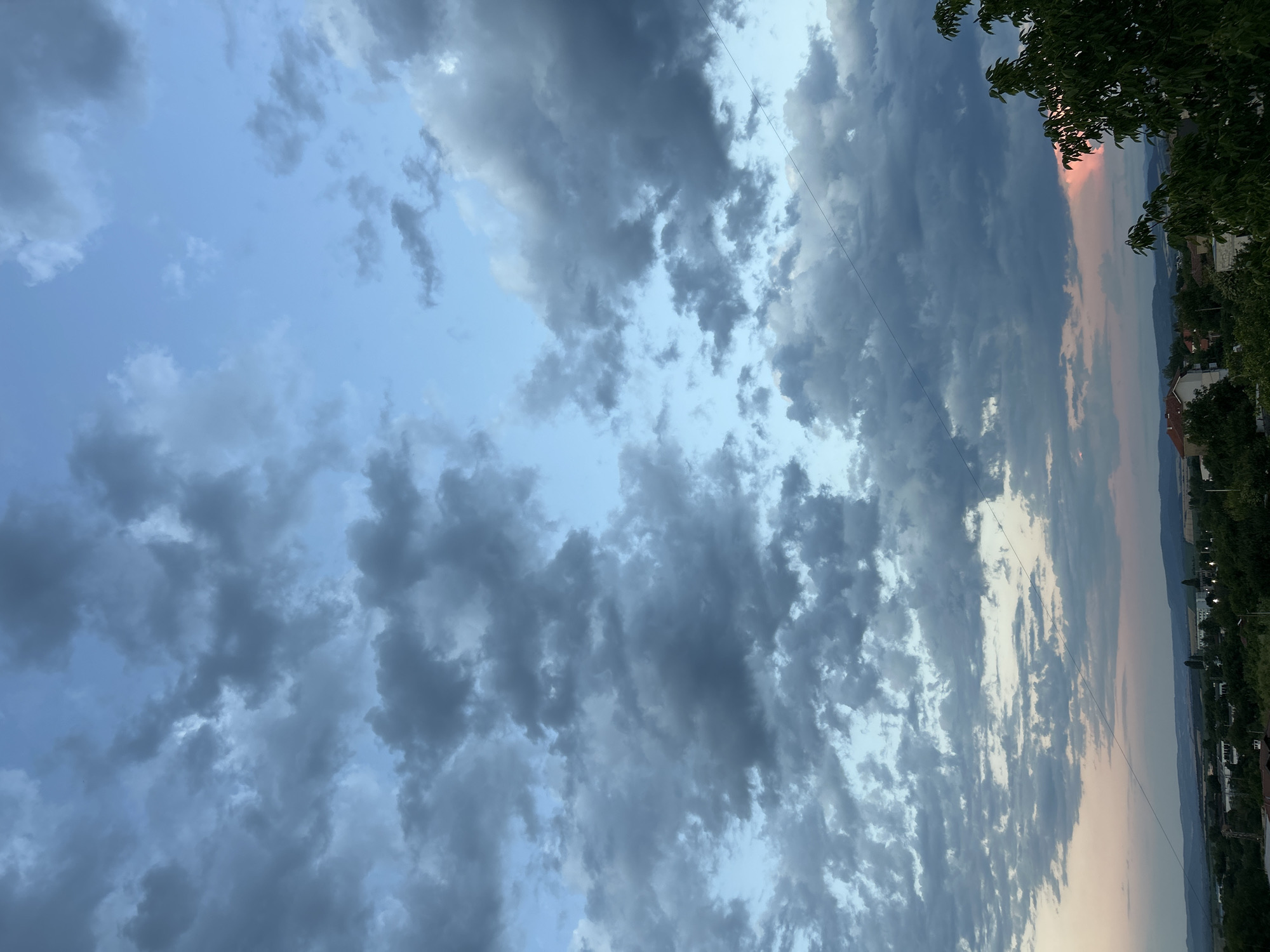 Dusk settles over urban outskirts under a dramatic cloudy sky