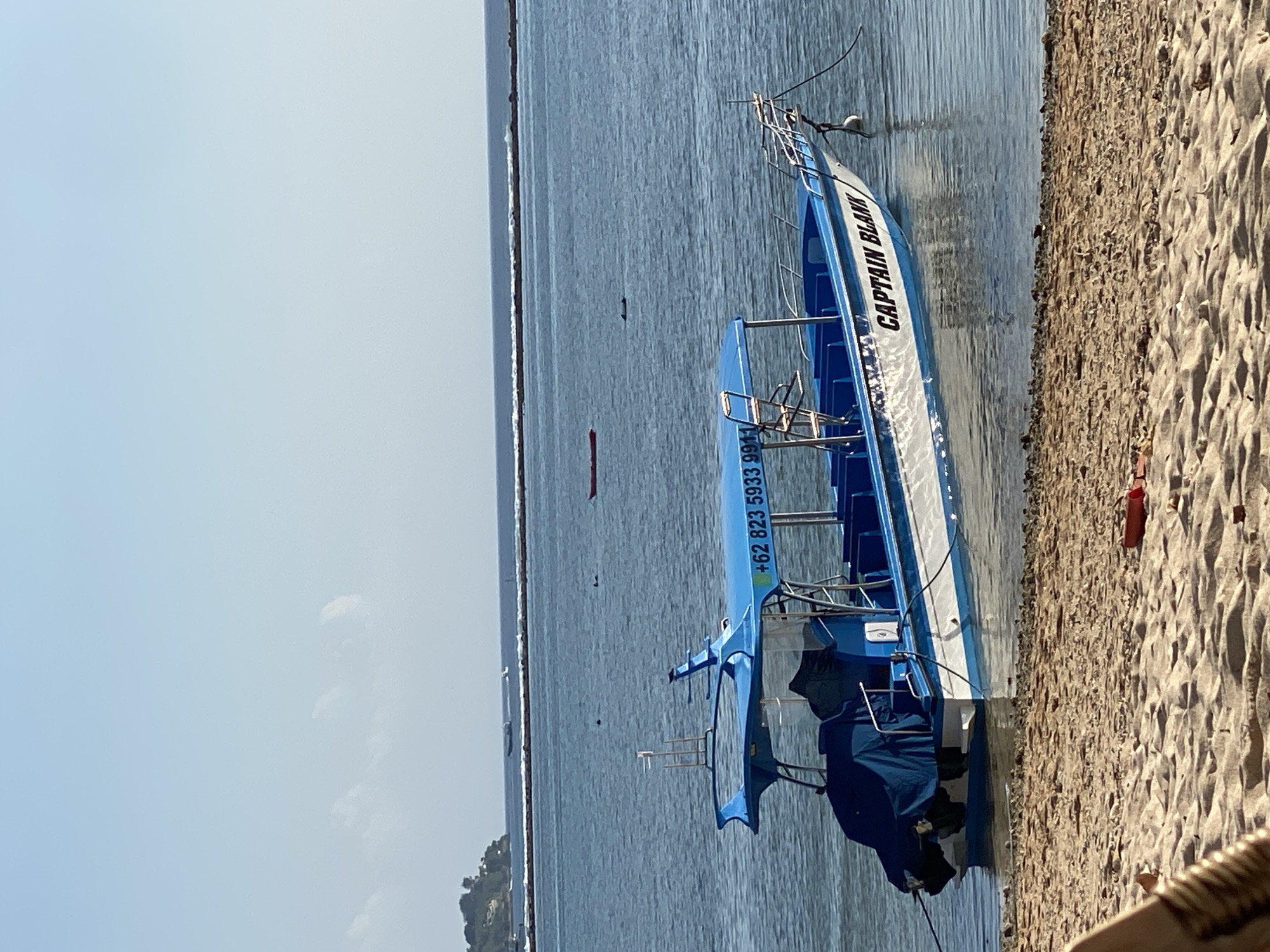 Quiet morning at a Nusa Penida beach with boats and shoreline scenes