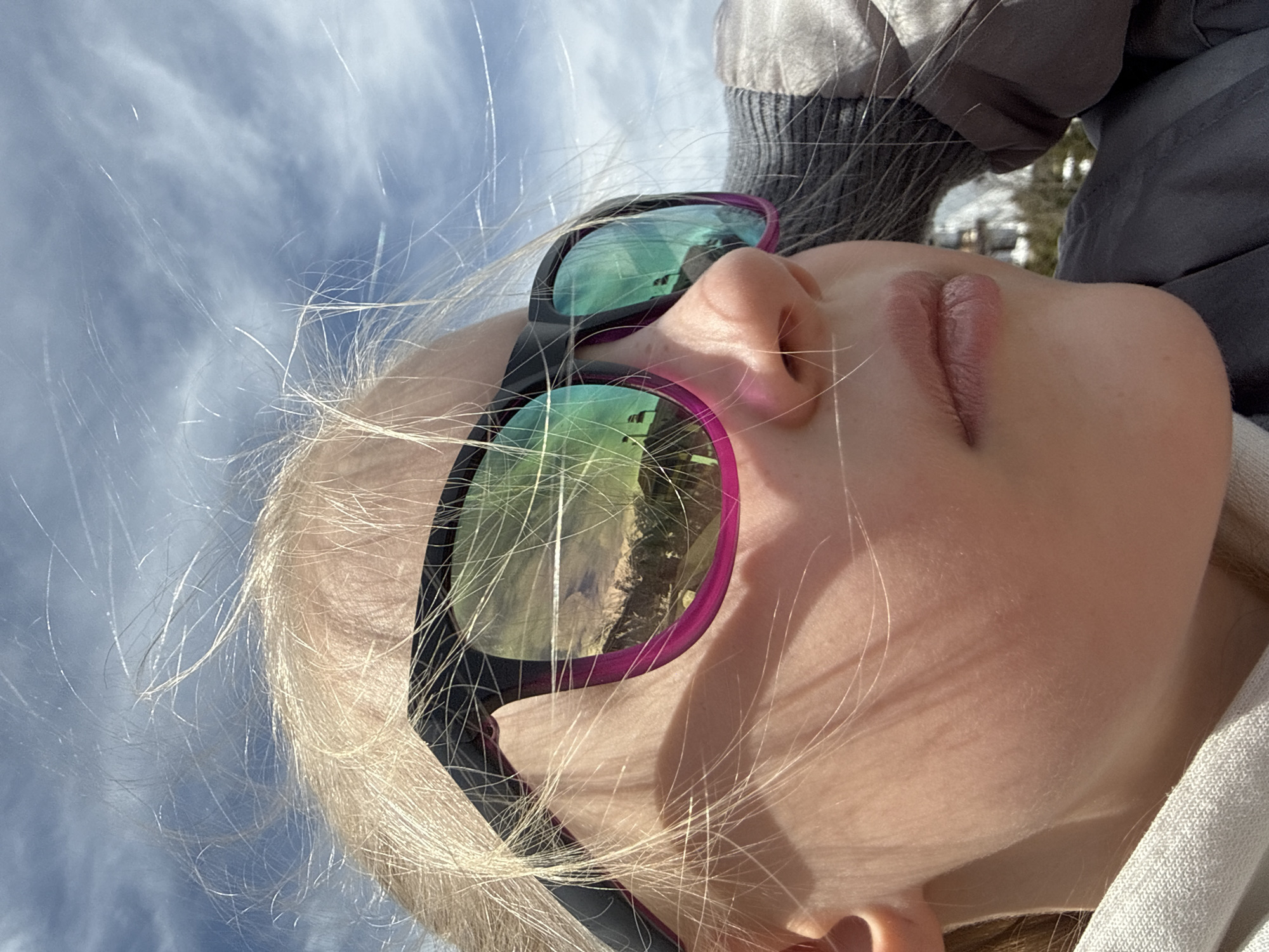 Blonde person in sunglasses photographed looking skyward in Russia