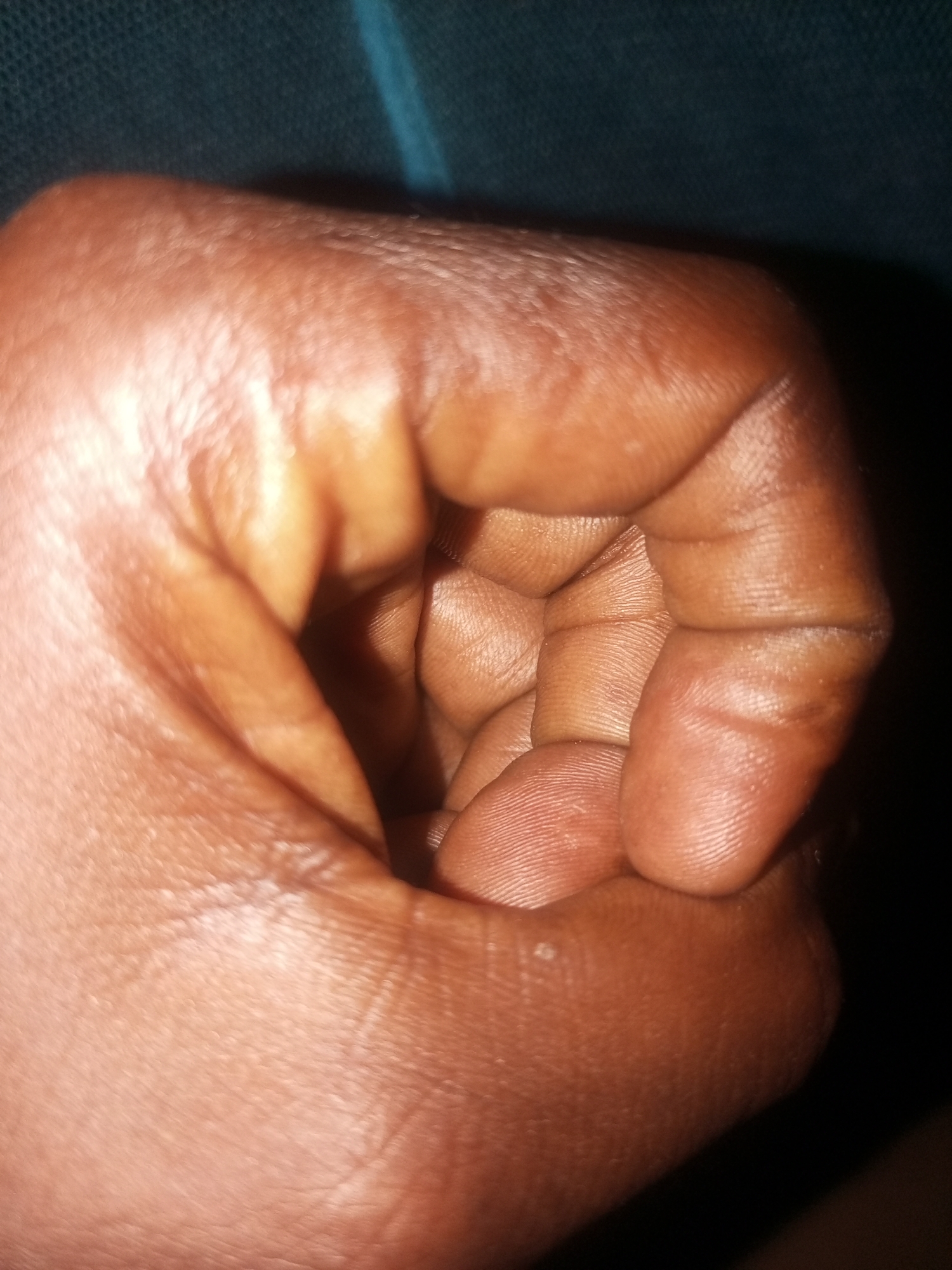 Clenched fist close-up, dark background, Tempure Nigeria