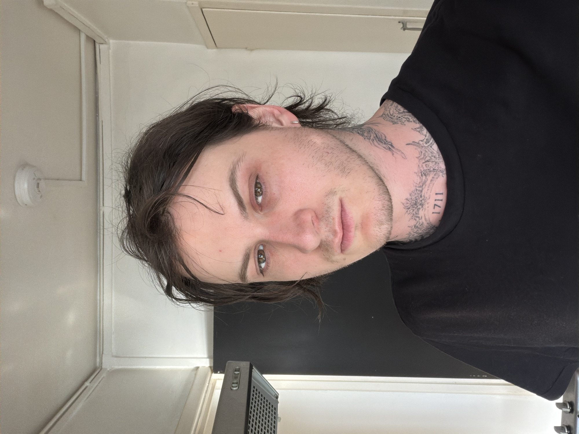 Person with tattoos observed indoors in London room