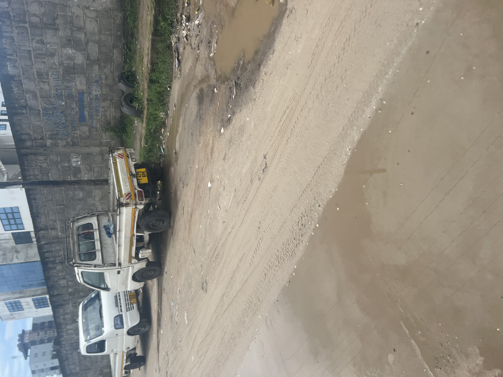 White truck parked on flooded dirt road in Dar es-Salaam