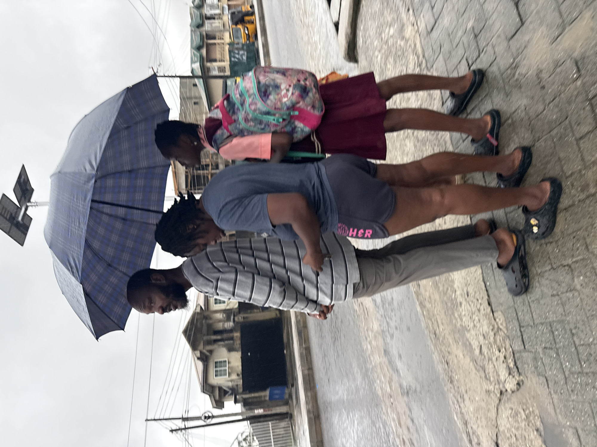 Rainy morning commute on foot through Ado, Nigeria