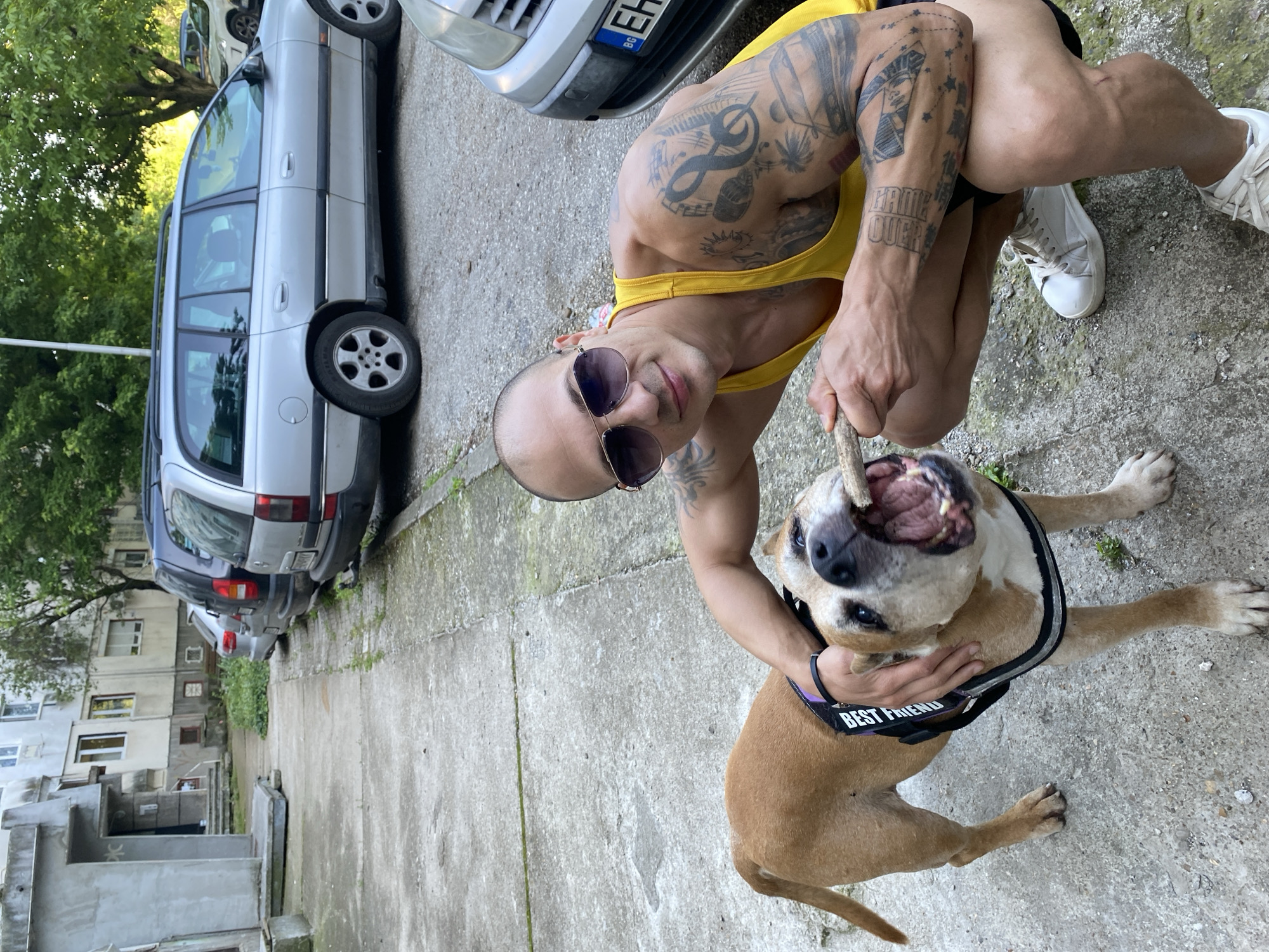 Tattooed man plays with dog in Pleven, Bulgaria