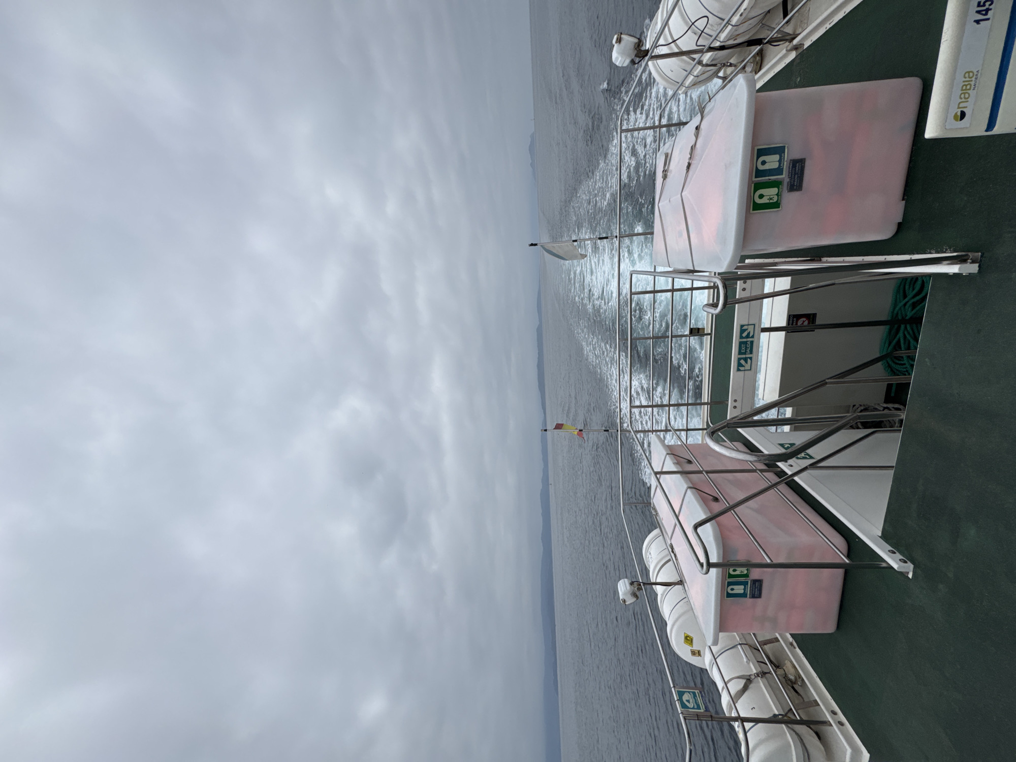 Ferry stern cutting through calm Galician coastal waters